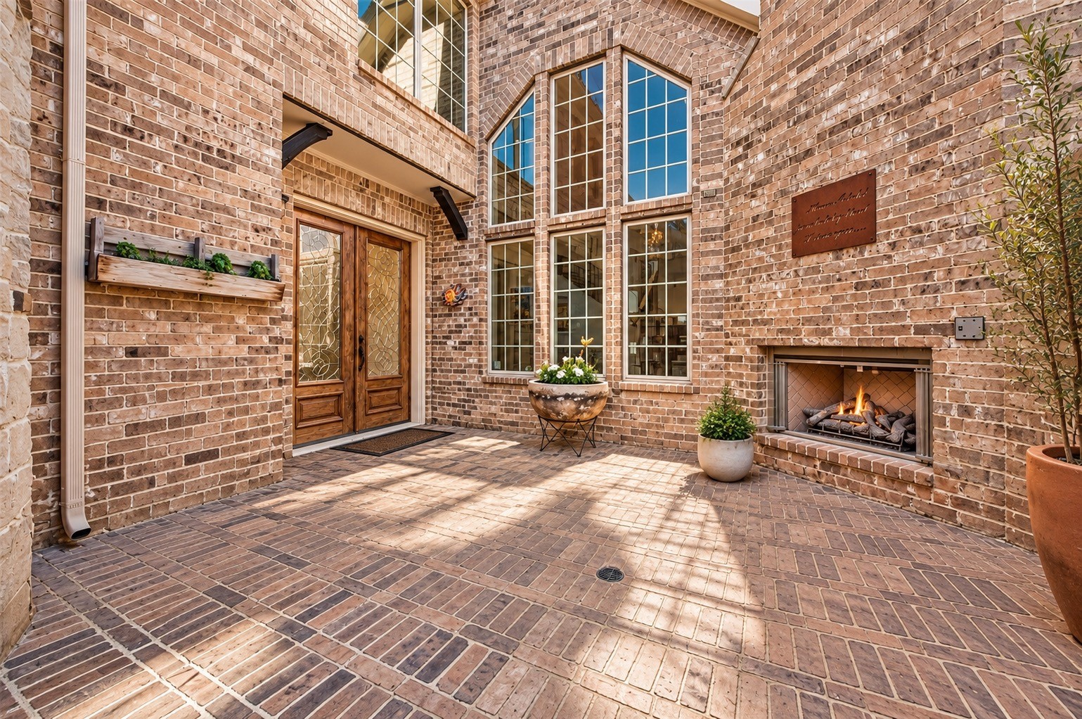 Private courtyard showcasing brick architecture, landscaping and abundant natural light.
