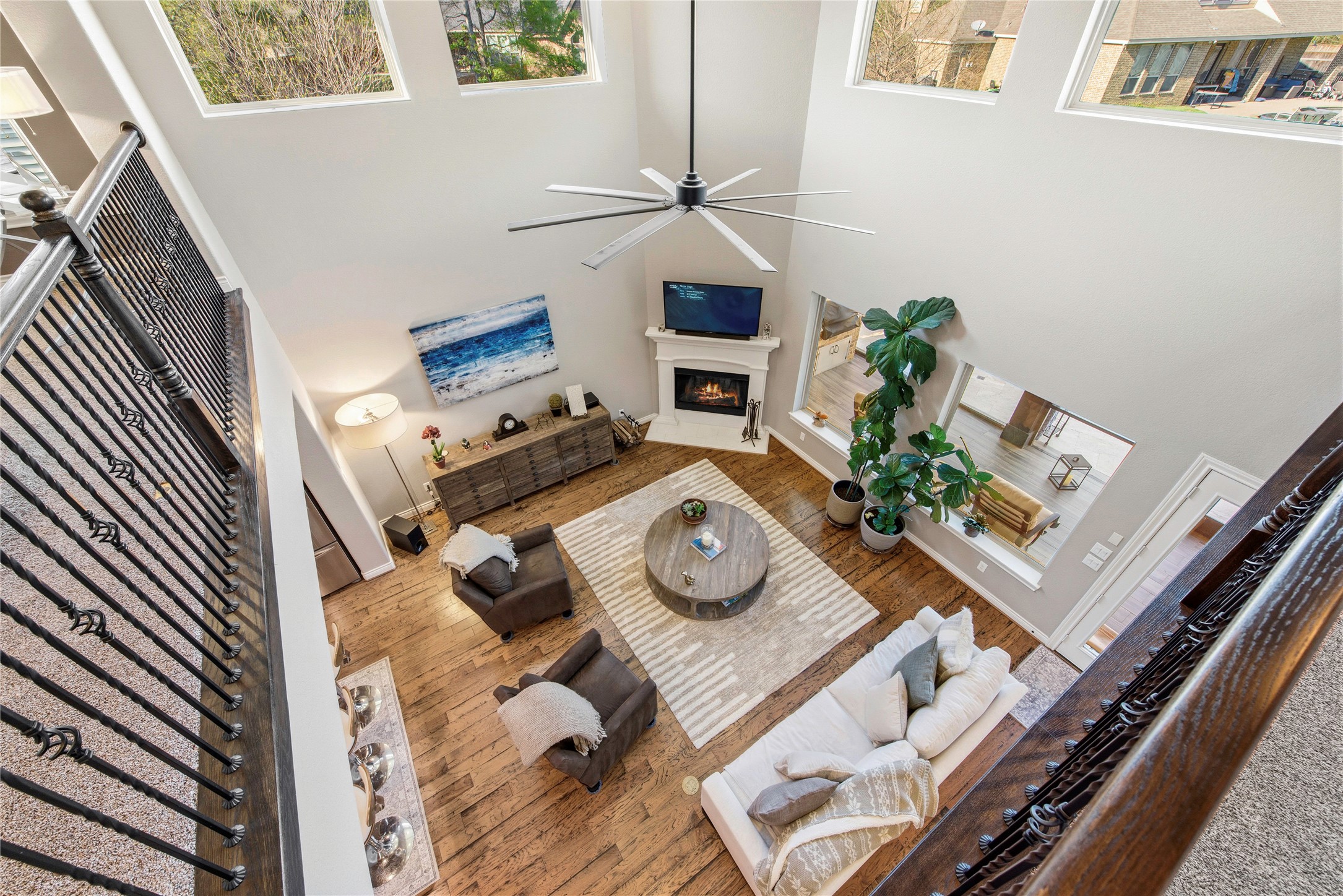 Open game room showcasing spacious seating areas, hardwood flooring and large windows.