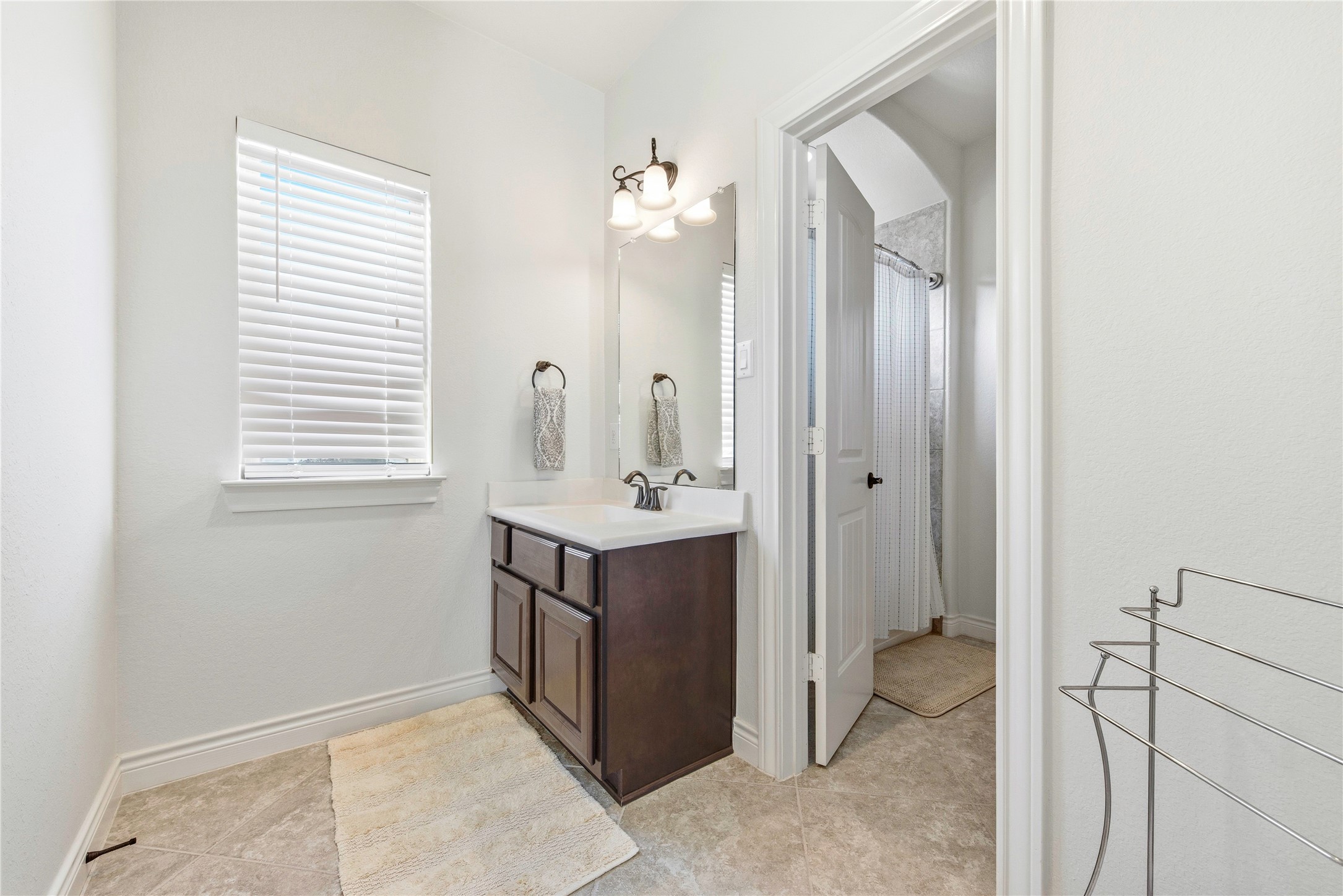 Well-appointed bathroom featuring vanity, mirror and walk-in shower.
