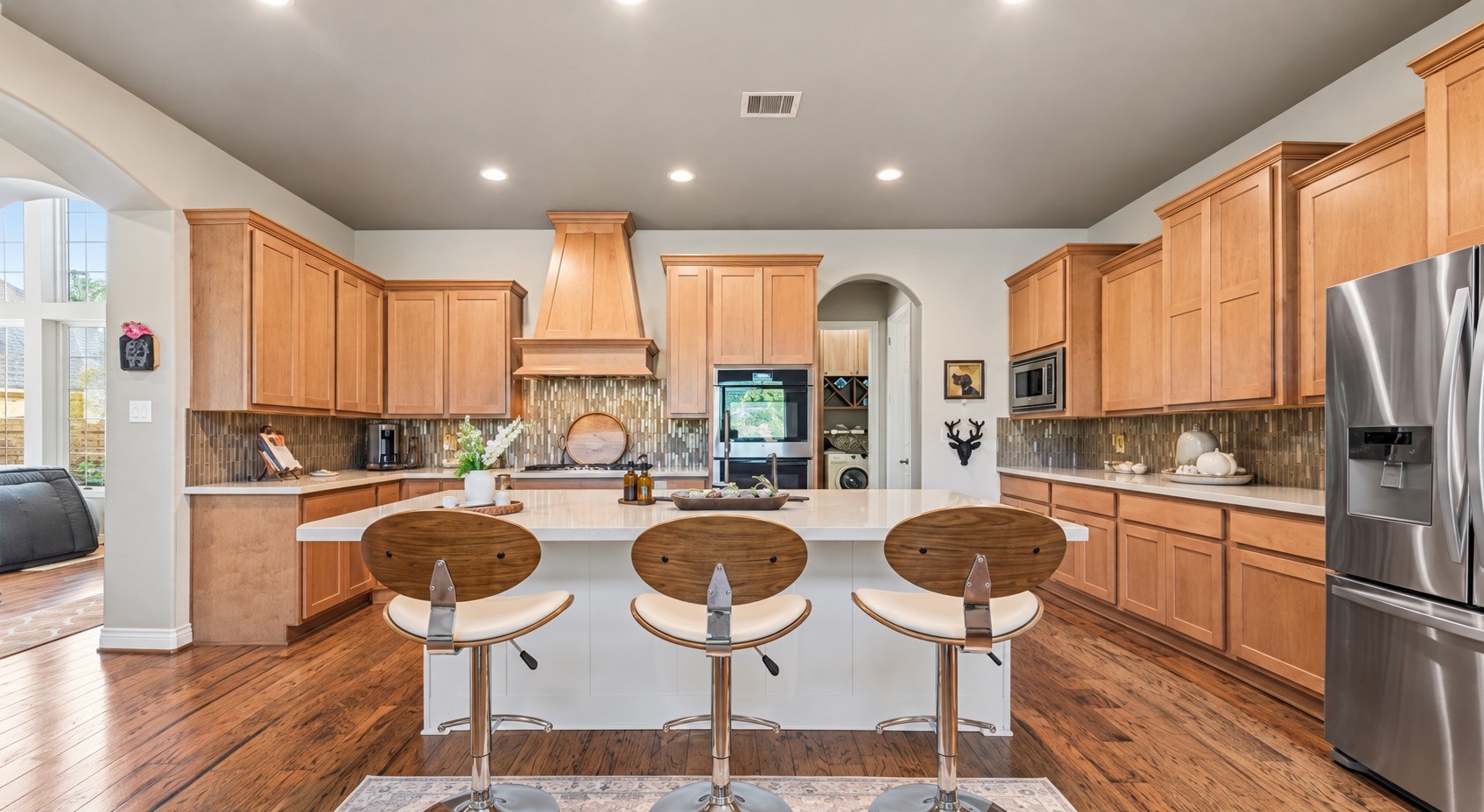 Gourmet kitchen featuring custom cabinetry, spacious island, bar seating and stainless appliances.