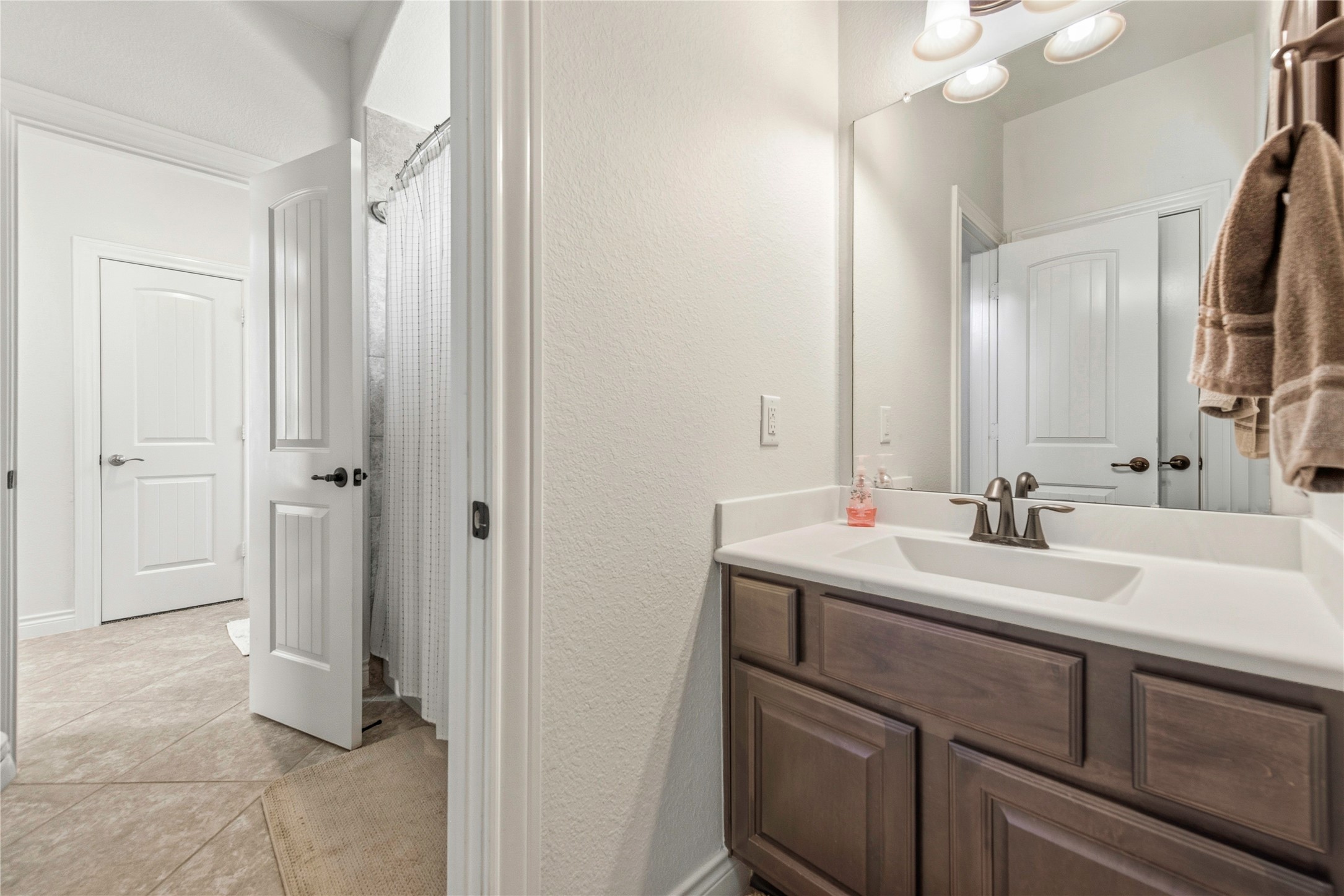 Spacious bathroom showcasing dual vanity, ample storage and bright finishes.