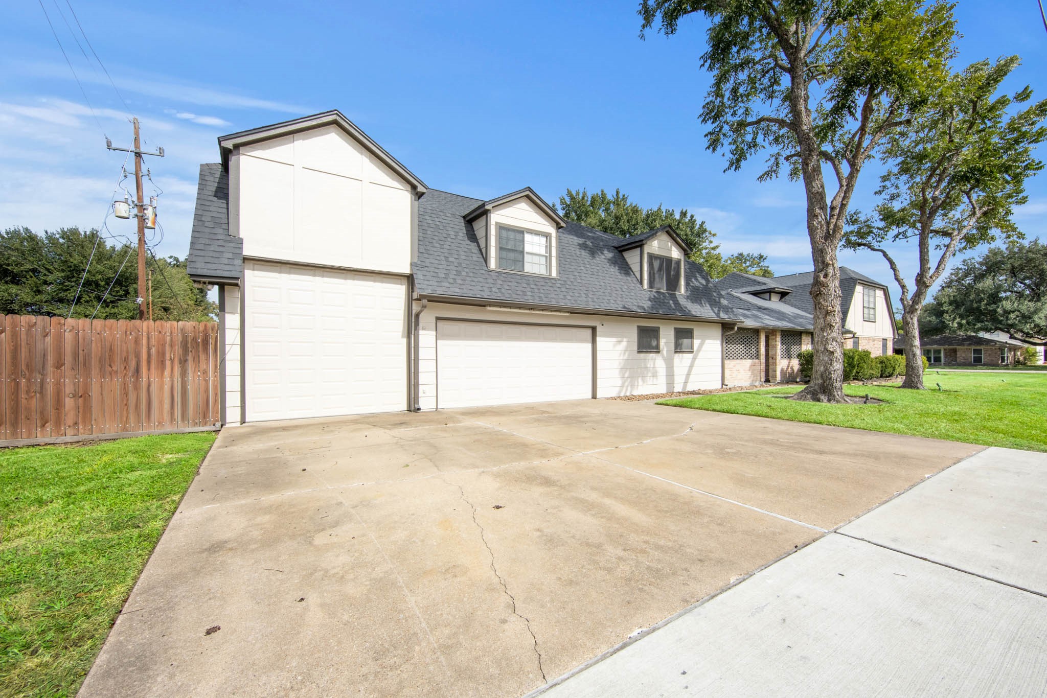 Oversized Concrete driveway that can easily fit 6 cars. The tall garage space has a roll up door Oversized Concrete driveway that can easily fit 6 cars. The tall garage space has a roll up door