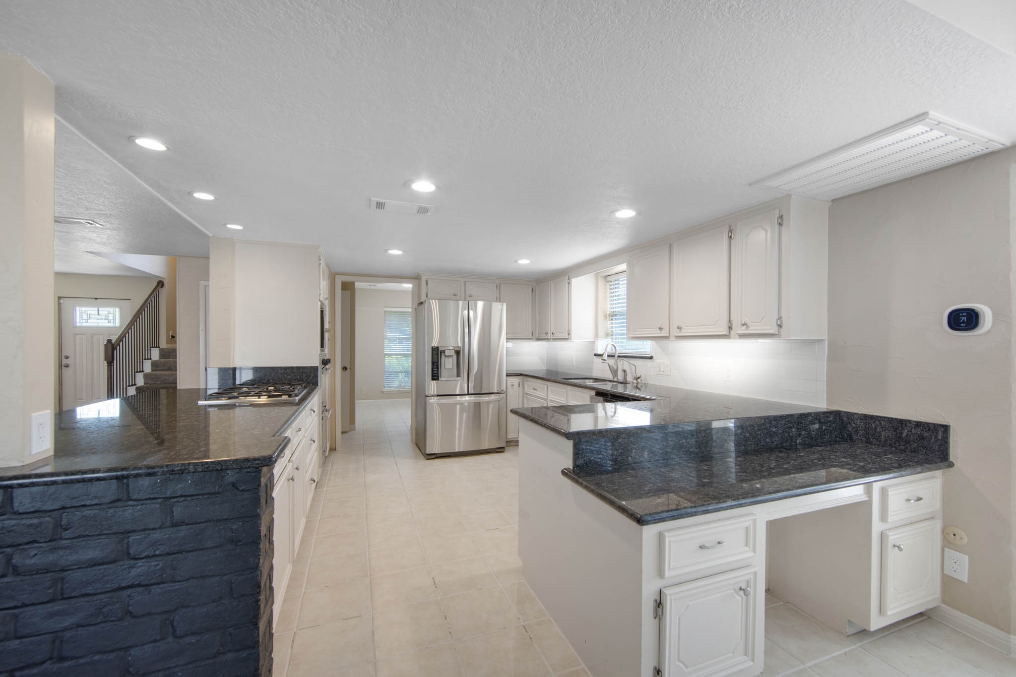 The kitchen has tile floors, granite counter tops, and a built in desk