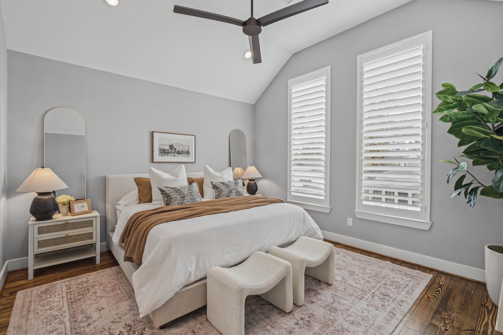 The spacious primary suite offers a peaceful retreat with windows overlooking the backyard.