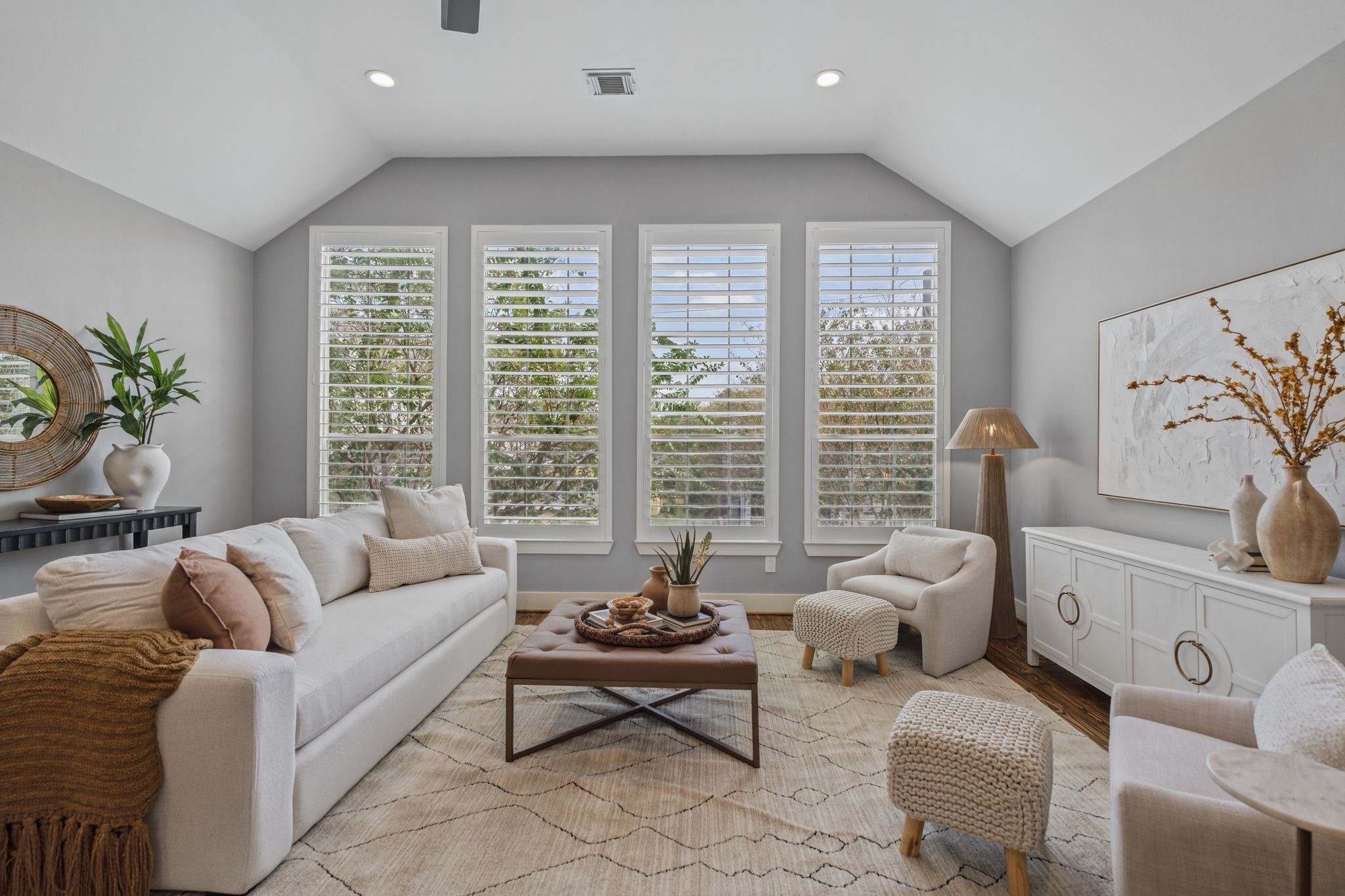 The second floor opens to an expansive living and dining area, filled with natural light from a wall of windows overlooking the front of the home.