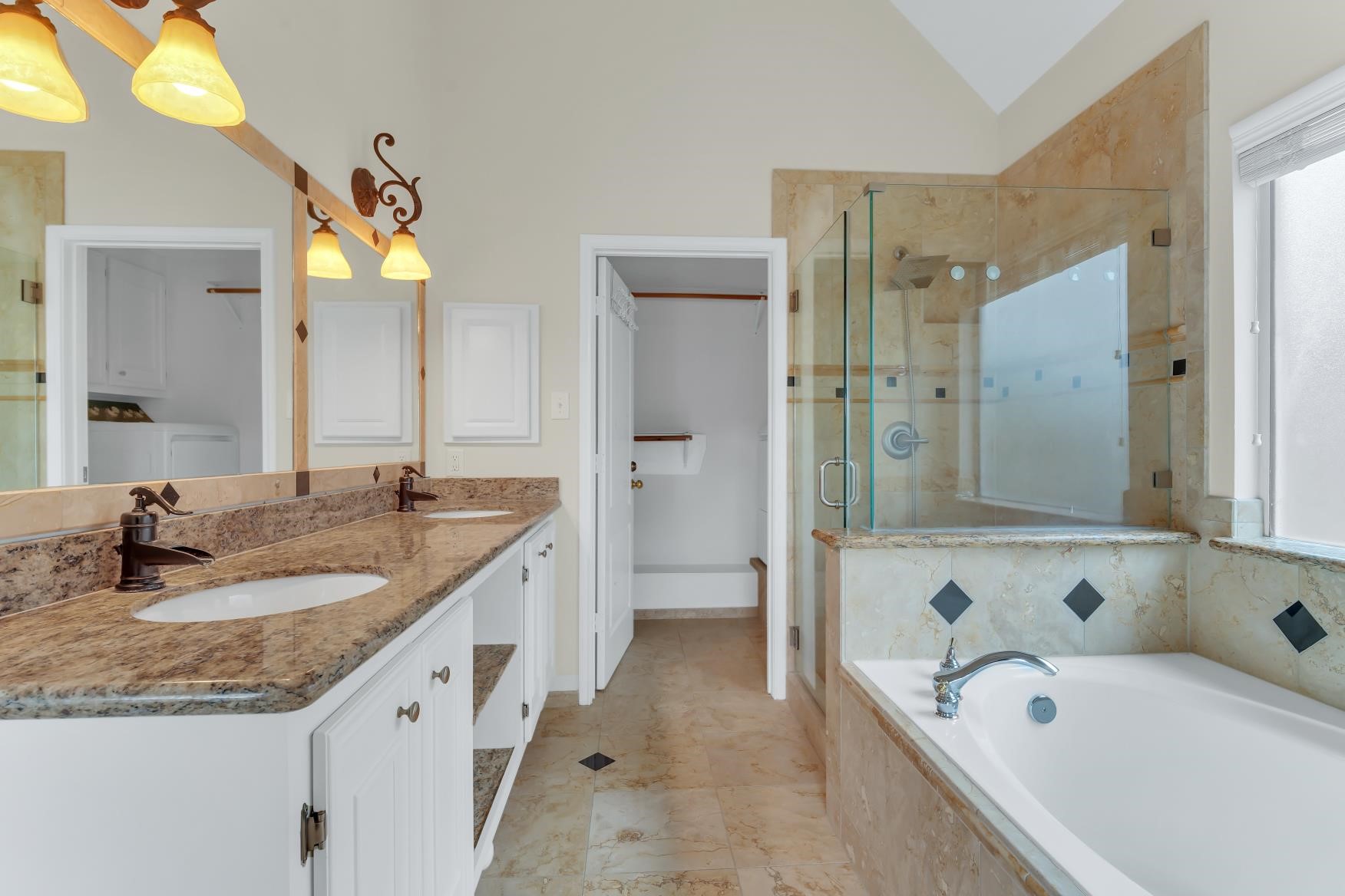 Luxurious primary bathroom featuring a double sink, elegant shower and relaxing bathtub.