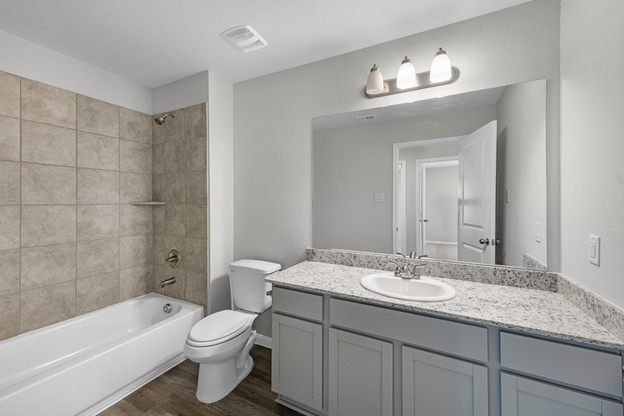 A shared full bathroom between the 2 guest bedrooms offers granite countertops, additional storage cabinets, and a tub/shower combo with tile surround.