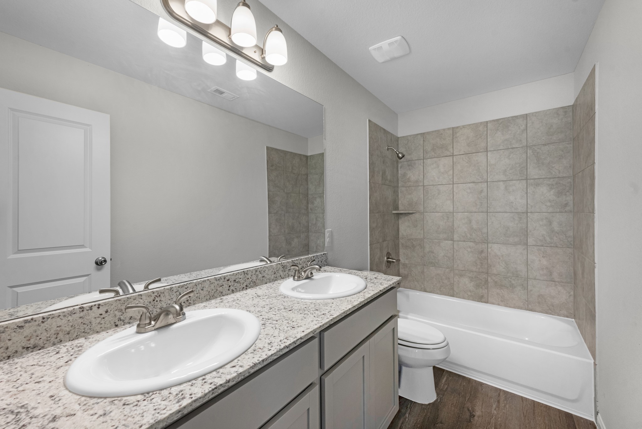 The primary bathroom includes double sinks, granite counters, and a tub/shower combo with tile surround.