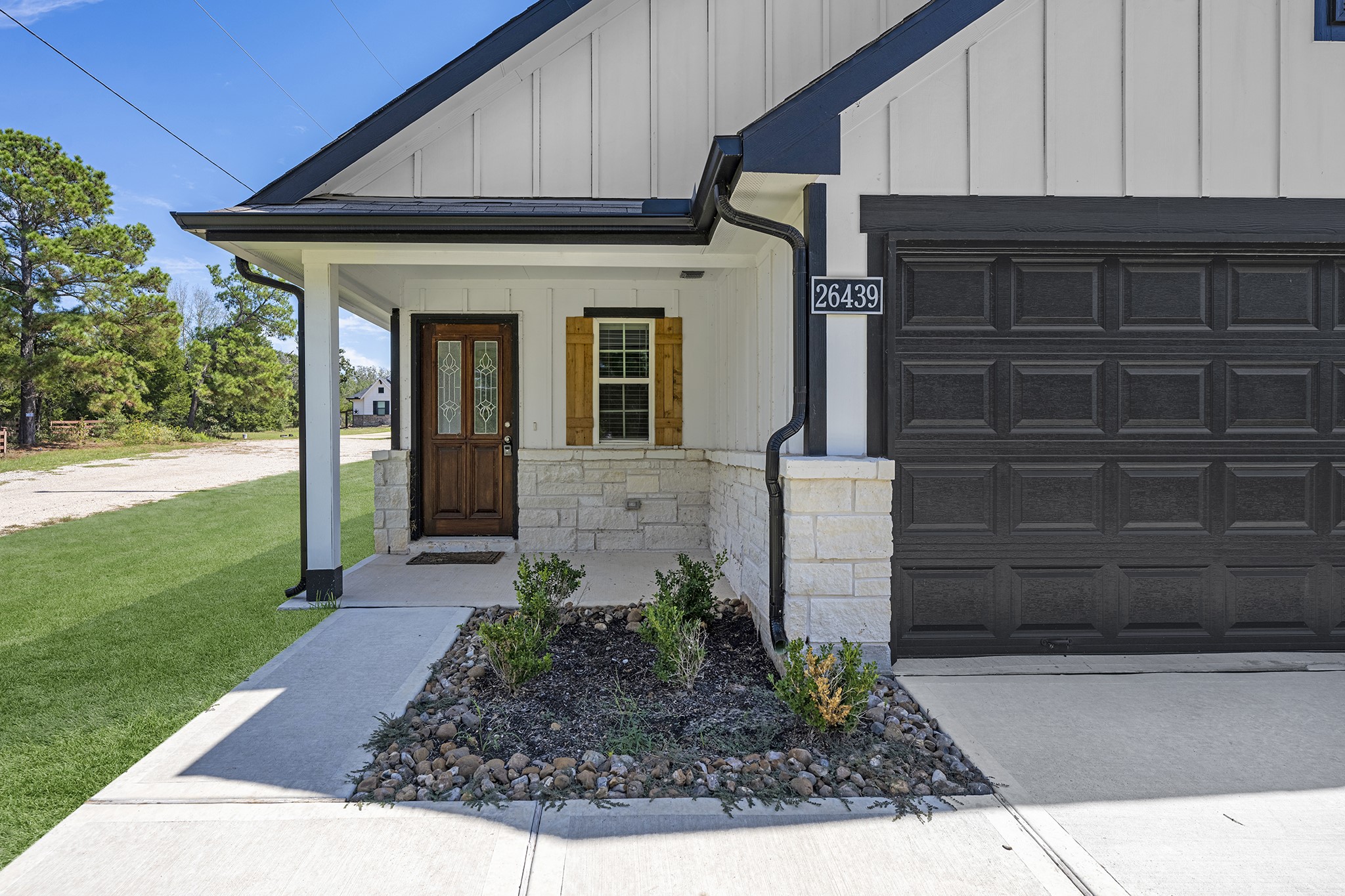 An inviting front porch with stone facade and wood accents greets you upon entering!