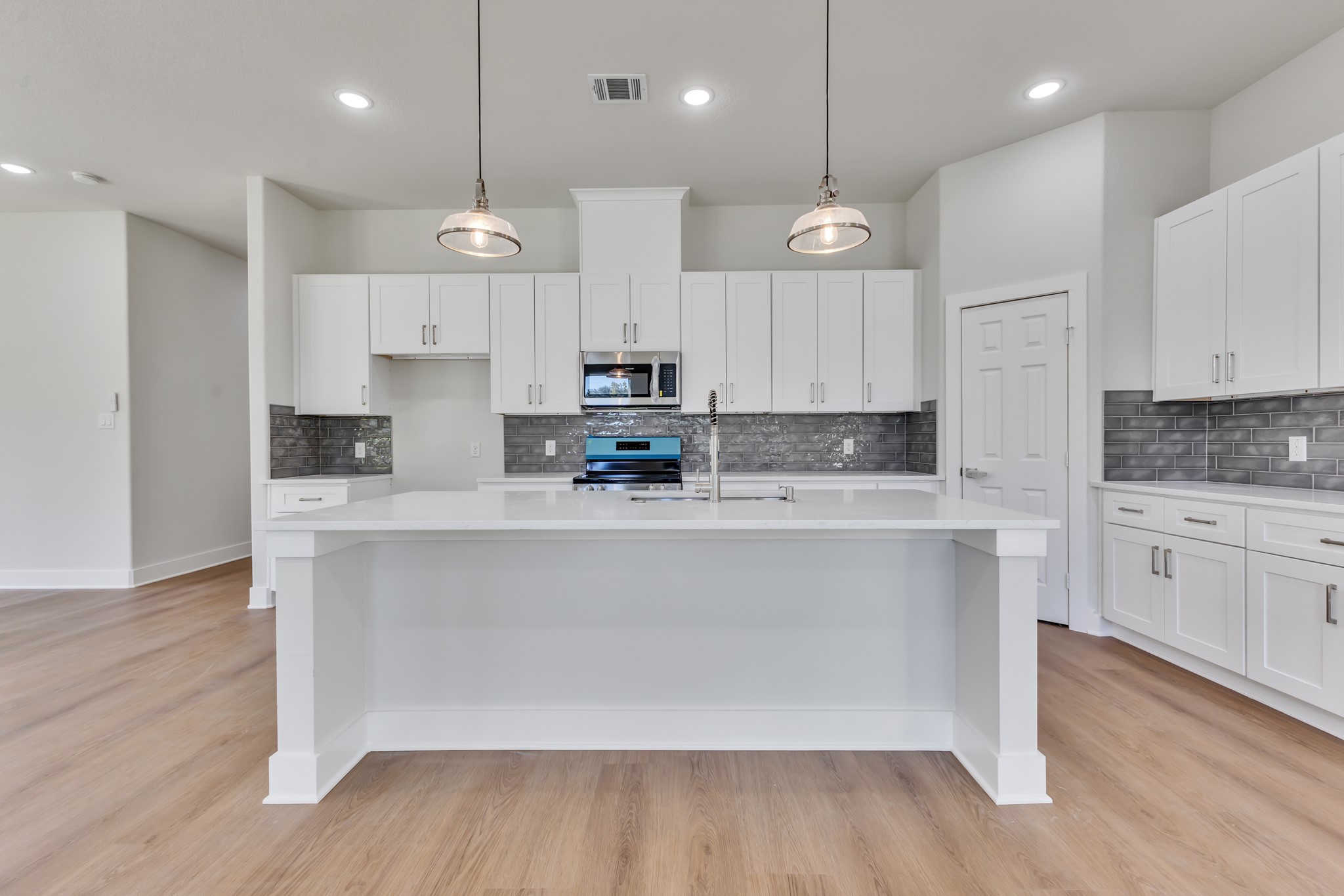 Kitchen Featuring Large Island and White Cabinetry