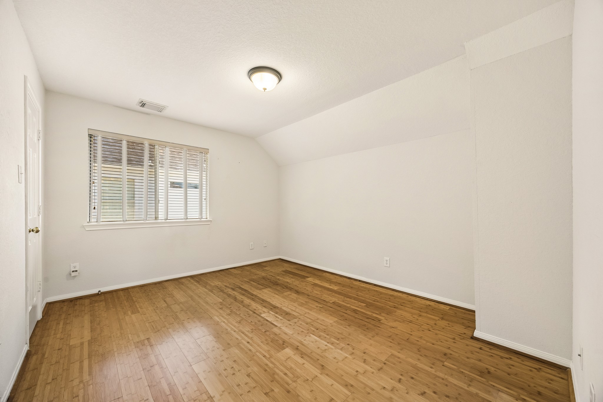 One of three guest bedrooms upstairs, this comfortable space offers warm bamboo flooring, neutral paint and plenty of space to create an inviting retreat for family or overnight guests.