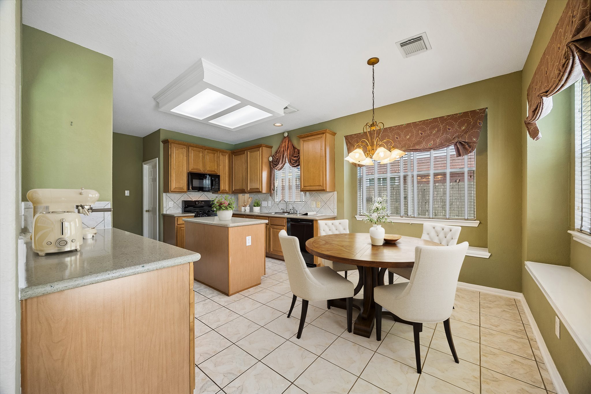Bright and open, the kitchen and breakfast area flow together beautifully with tile flooring, designer paint, quartz countertops, classic wood cabinetry, a center island and built-in window seats that make casual meals feel right at home.