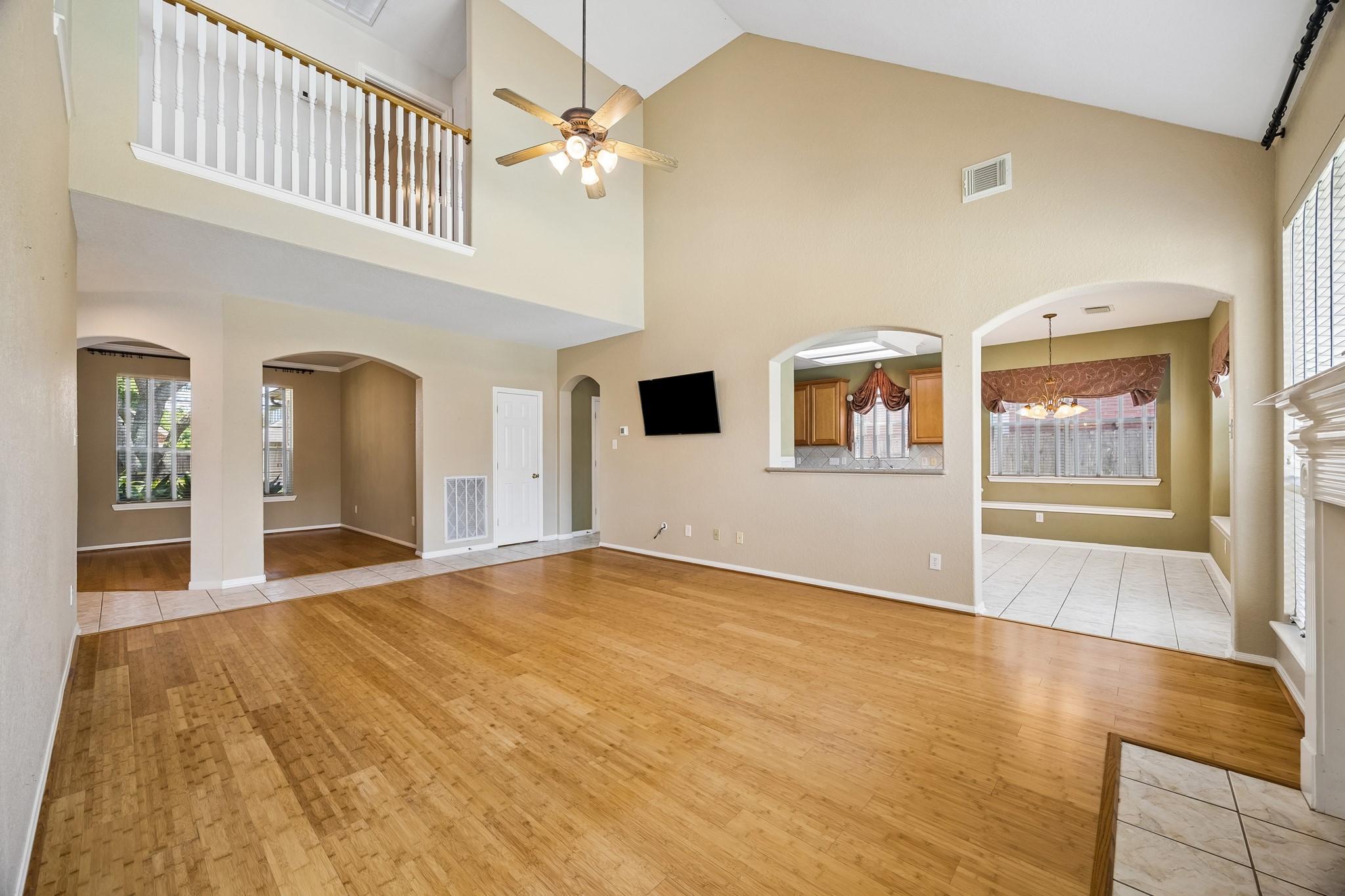 A soaring vaulted ceiling gives this spacious family room an open, airy feel, while warm bamboo flooring, neutral paint and an easy connection to the kitchen and both dining areas make everyday living and entertaining feel effortless.
