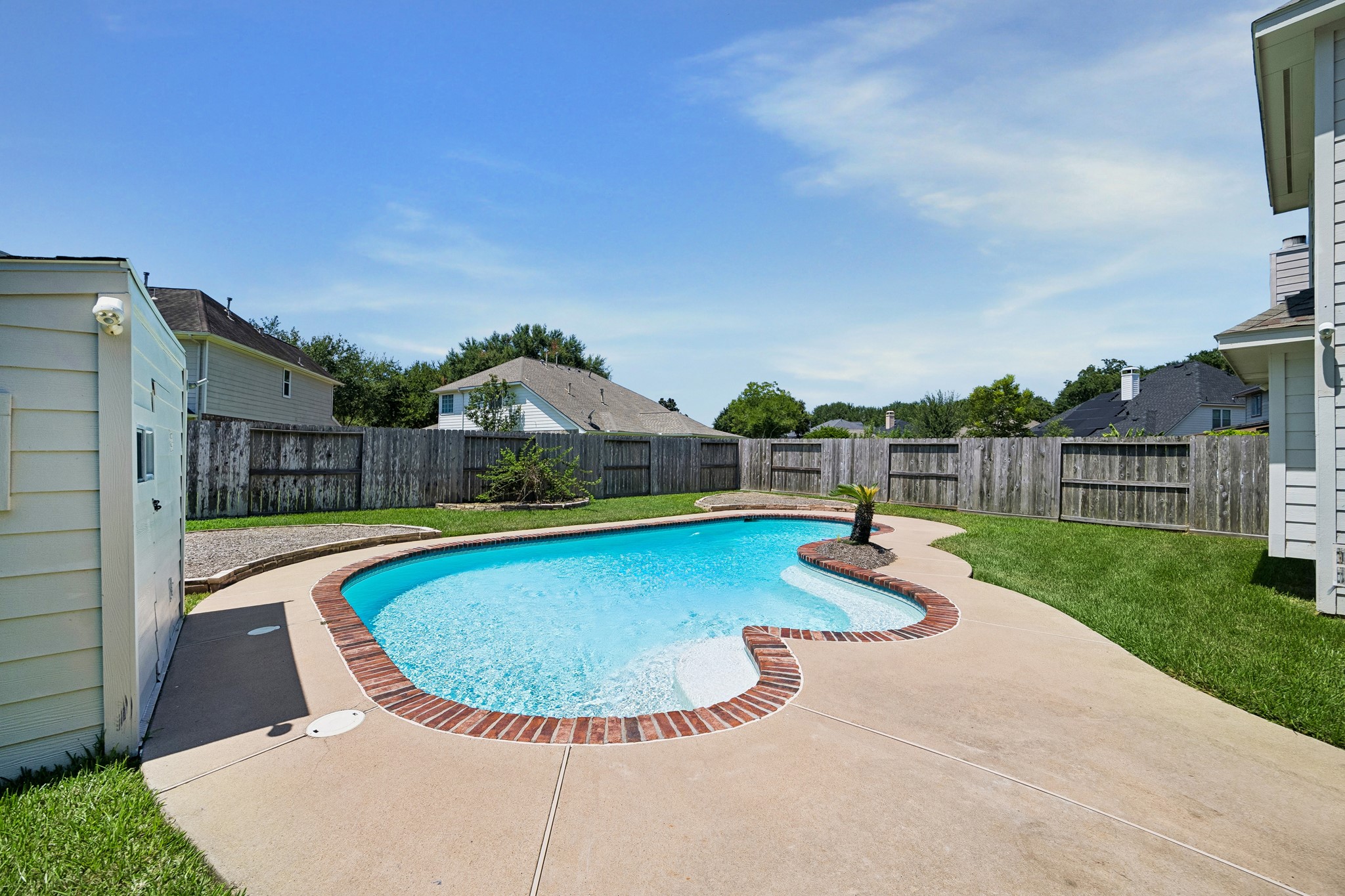 The backyard feels like its own private escape with a spacious inground pool just steps from the house, making it easy to move from indoor living to sunny afternoons and poolside fun.