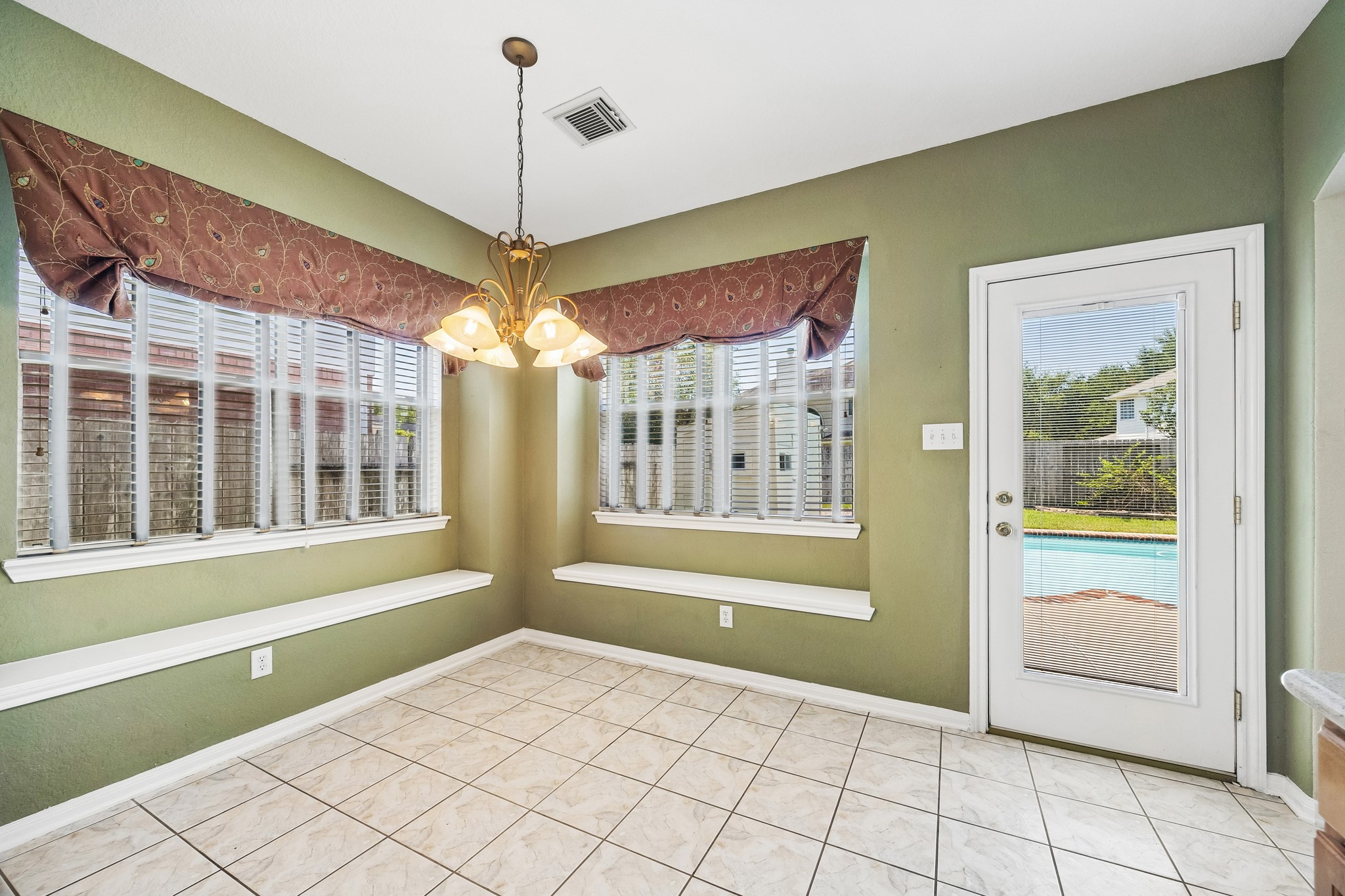 Breakfast comes with a backyard view in this sunny dining area, where corner windows, built-in seating and direct access to the patio and pool make it easy to move from everyday meals to outdoor fun.