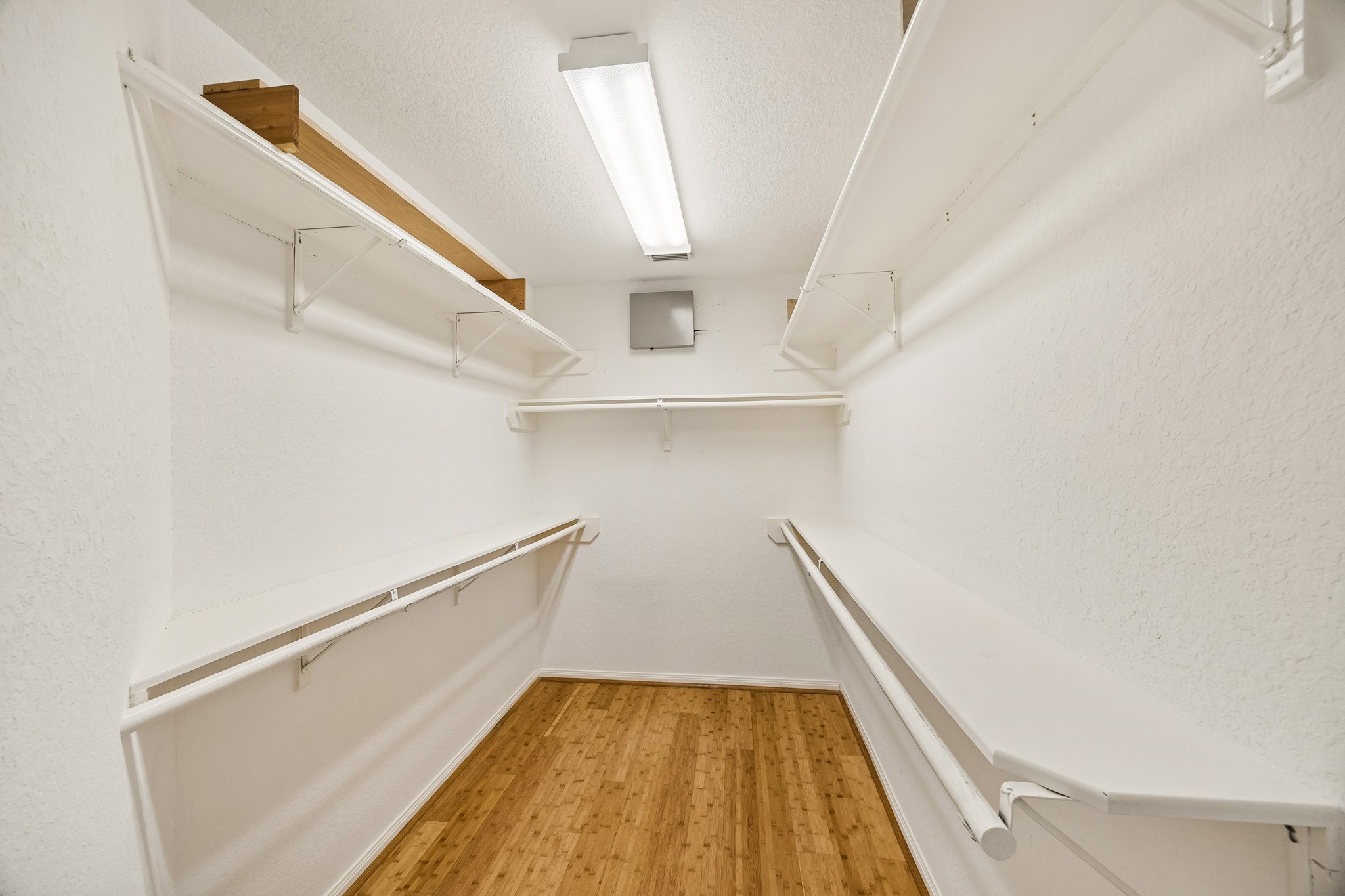 Go ahead, shop until you drop! This deep walk-in closet can take it with ample hanging bars for clothes and shelving for all the extras.