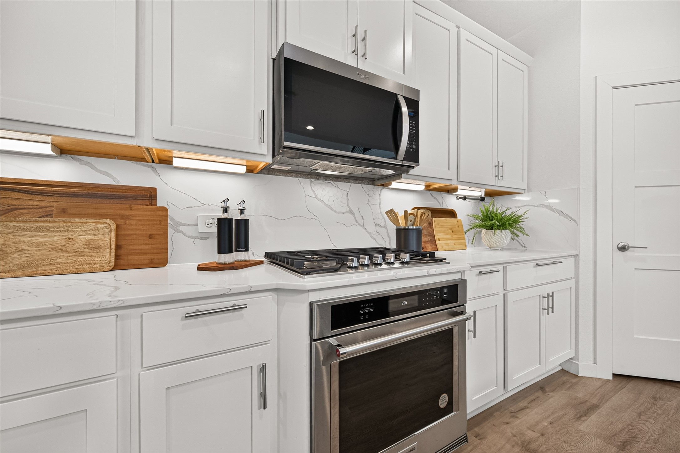 Chefs dream with a sleek stainless steel five-burner gas cooktop and stylish kitchen.