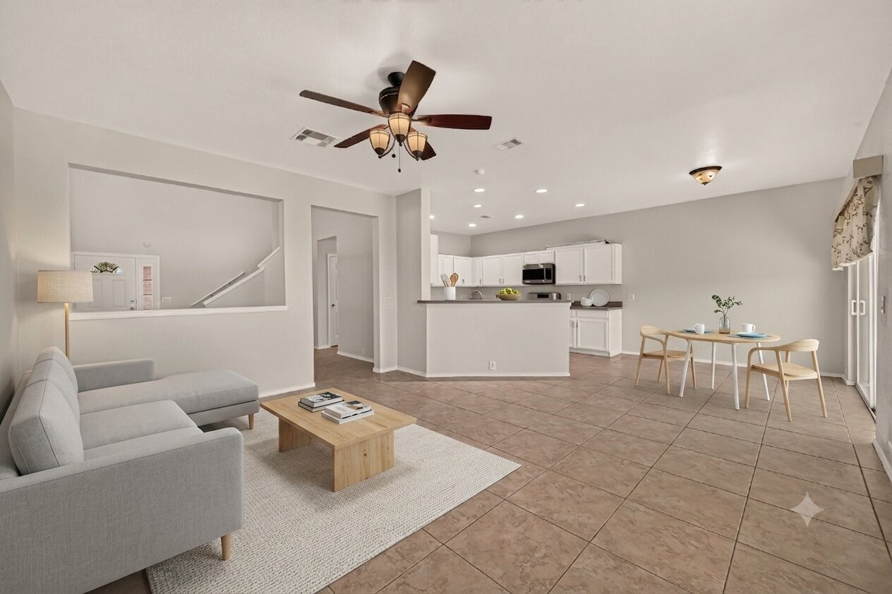 This virtually staged family room offers a spacious, light-filled haven with modern furnishings, seamlessly connecting the living and kitchen areas for effortless entertaining and everyday comfort.