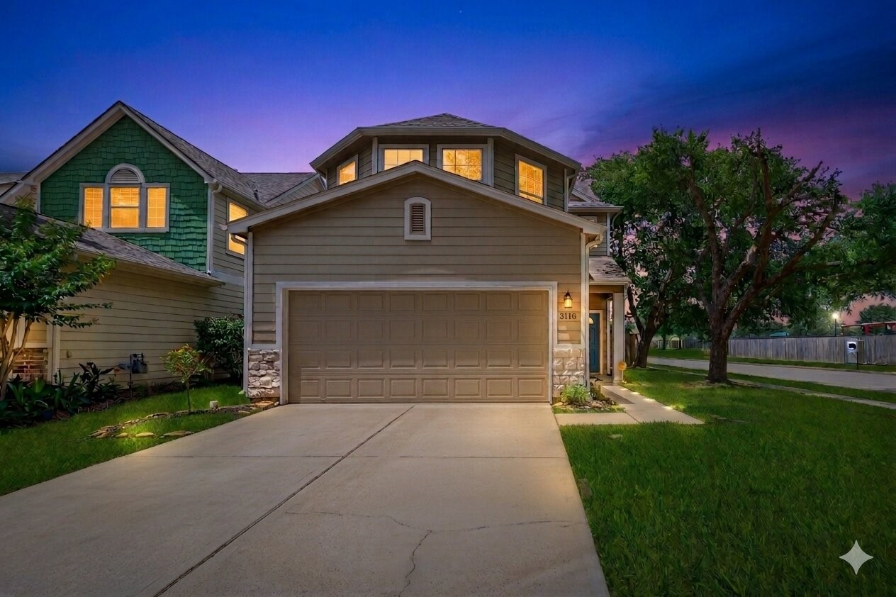 Charming two-story home with a spacious driveway and attached garage. Features a well-maintained lawn and mature trees, set against a picturesque evening sky. Ideal for family living in a serene neighborhood.