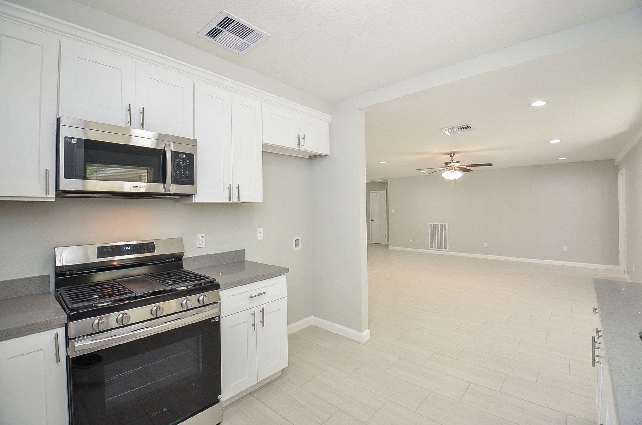 The kitchen is equipped with stainless steel appliances and beautiful tile flooring.