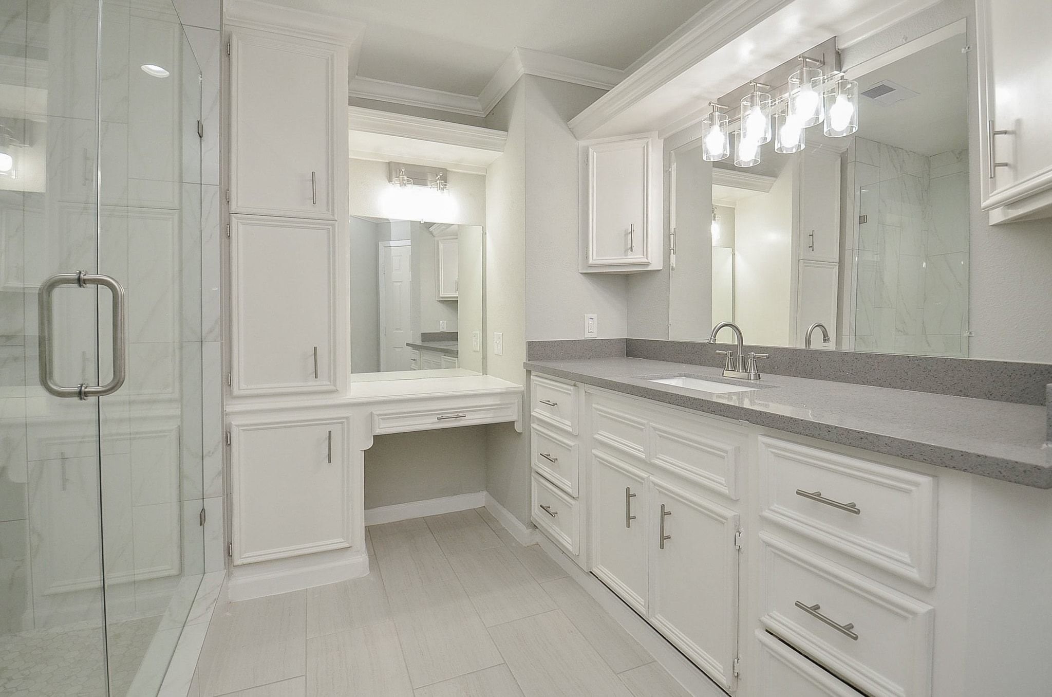Welcome the primary bathroom. The beautiful grey countertops allow plenty of storage space along with an ample amount of cabinetry.