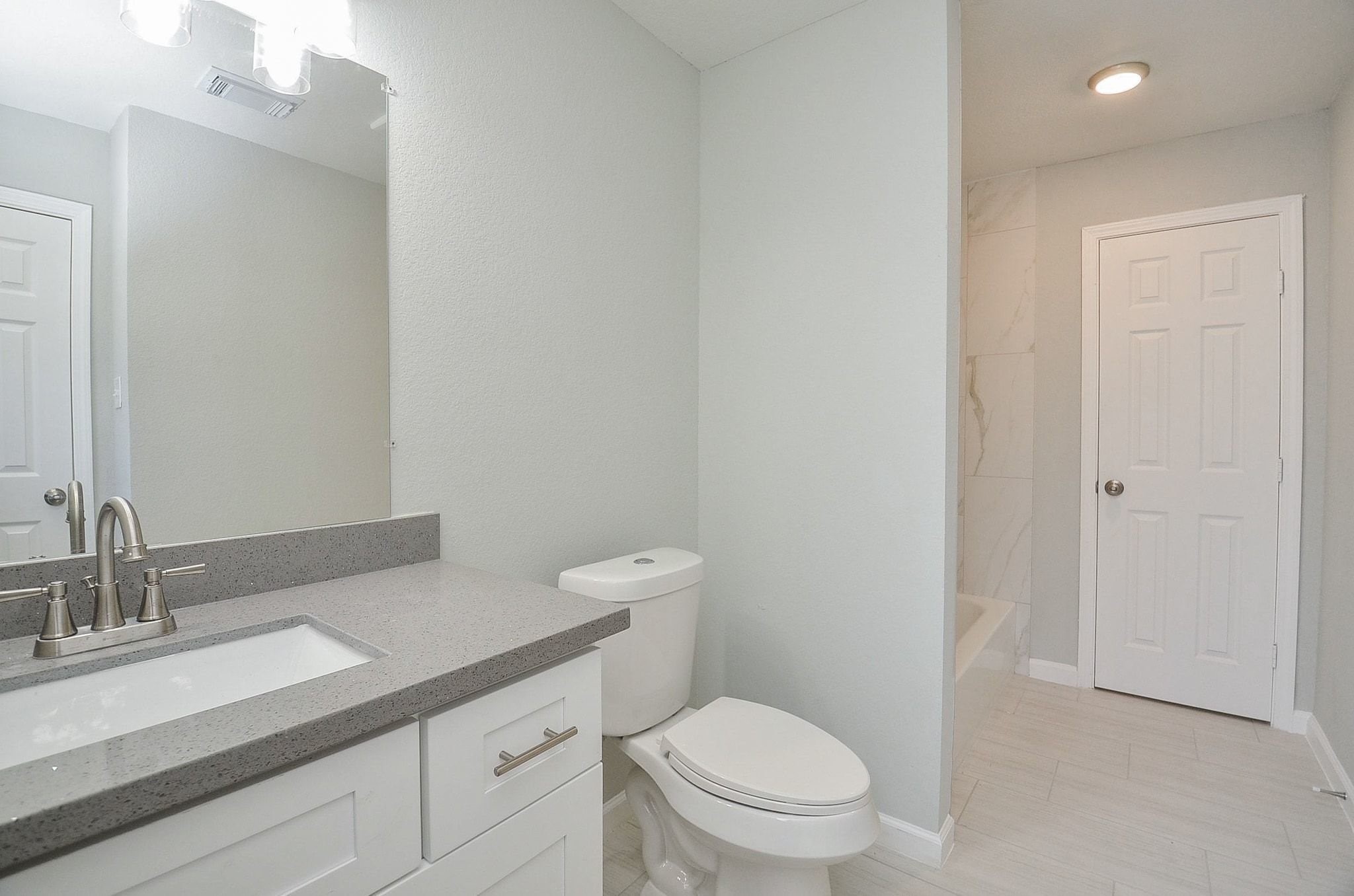Discover this shared bathroom that is equipped with gorgeous appliances and a shower/tub combination.