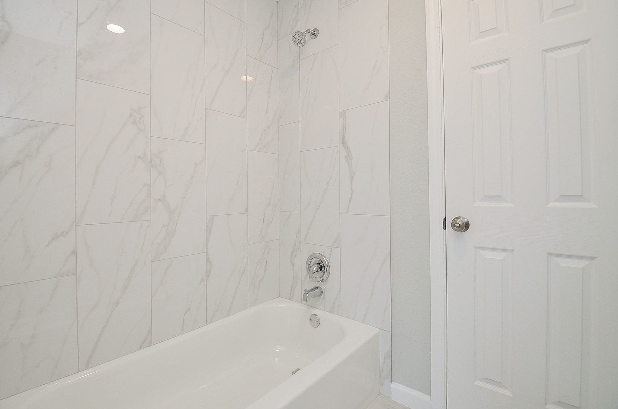This shared bathroom has a shower/tub combination with the same beautiful shower wall as the primary bathroom.
