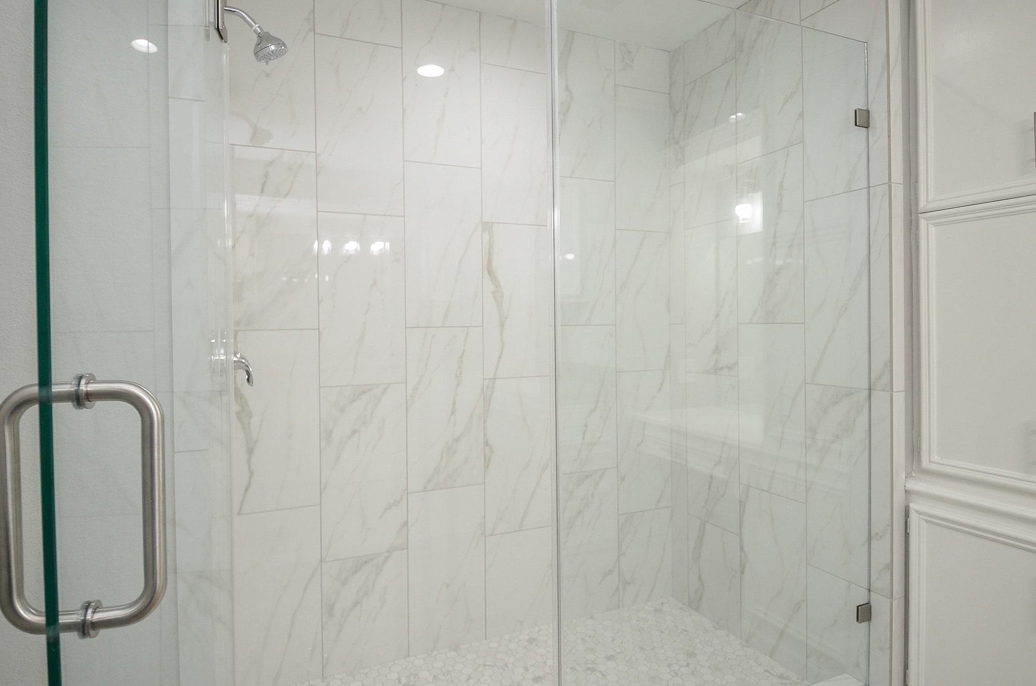 Notice the gorgeous and spacious shower wall, with a glass enclosed door.