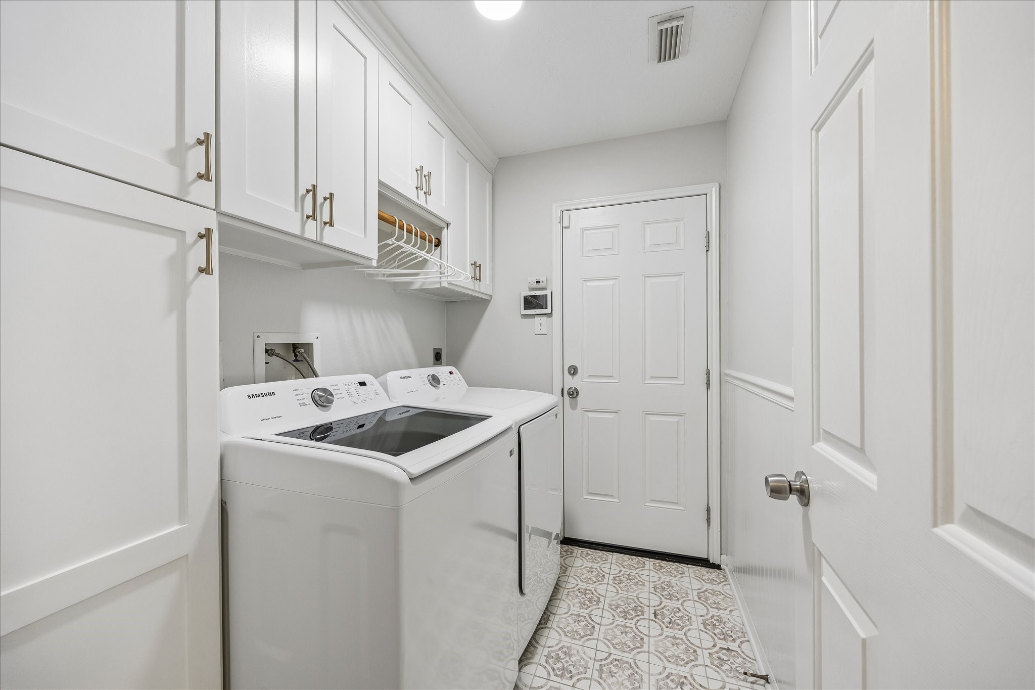 Who says a laundry room cant be beautiful? Thoughtfully upgraded with custom cabinetry, generous storage, and stylish tile flooring, this impressive utility room brings both organization and everyday convenience to a space thats often overlooked!