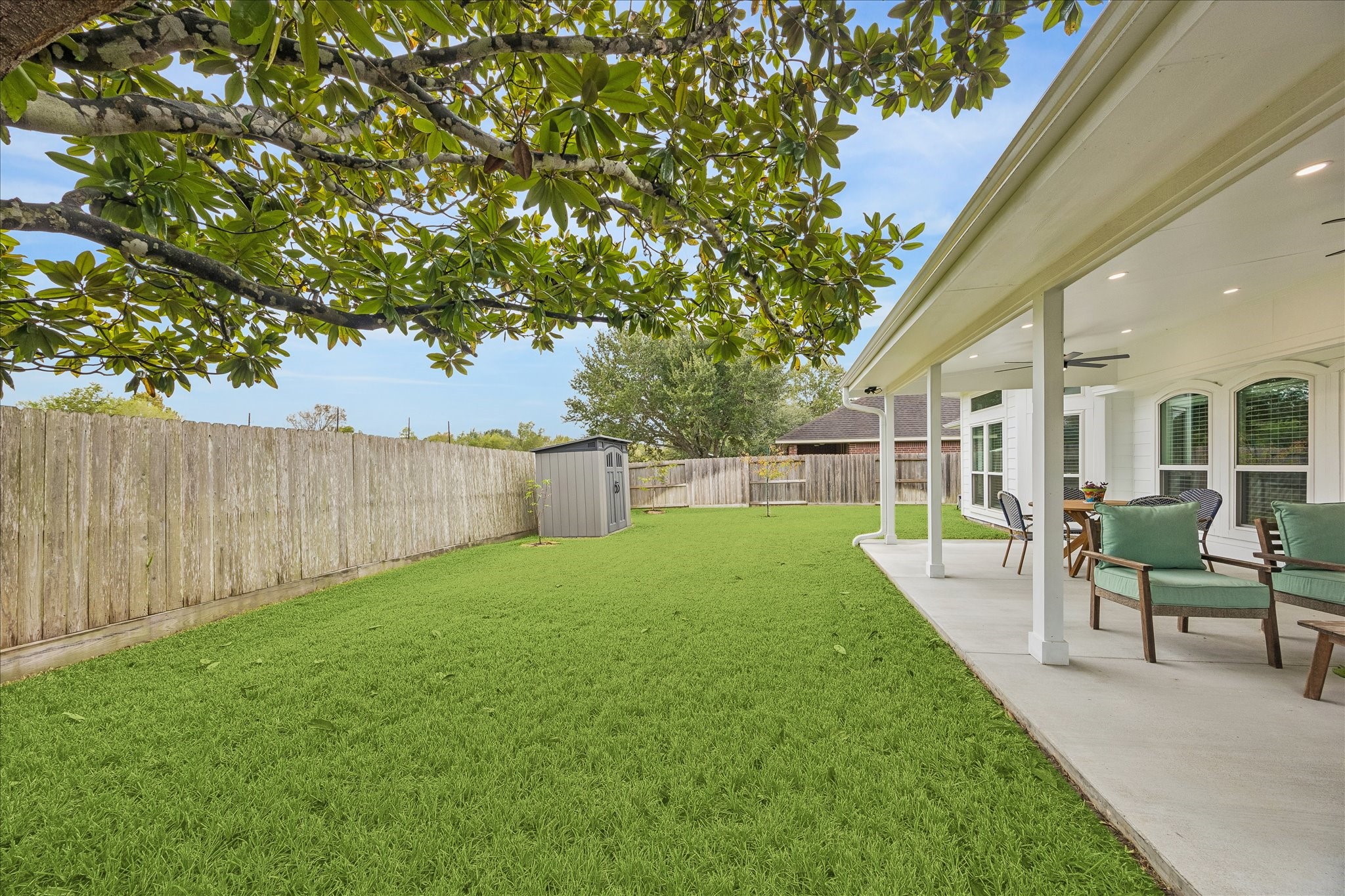 Your backyard oasis awaits! This beautiful view showcases the expansive covered patio and lush green lawn, offering plenty of space for outdoor dining, entertaining, or simply enjoying the peace and privacy of having no rear neighbors.
