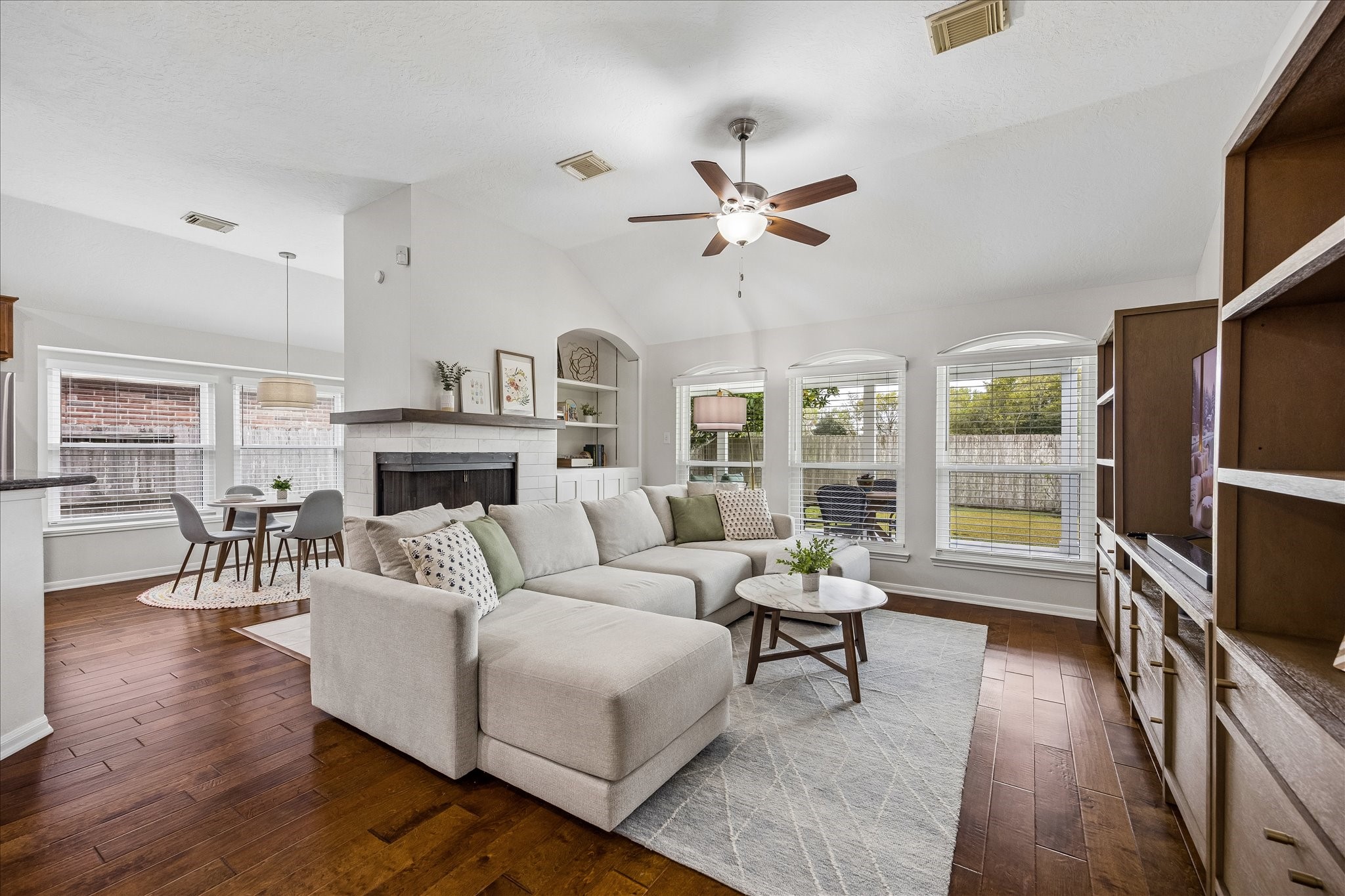 The heart of the home! This beautifully appointed family room features soaring ceilings, gorgeous built-ins, a striking remodeled fireplace, and walls of windows that fill the space with natural light. The perfect blend of elegance and everyday comfort!