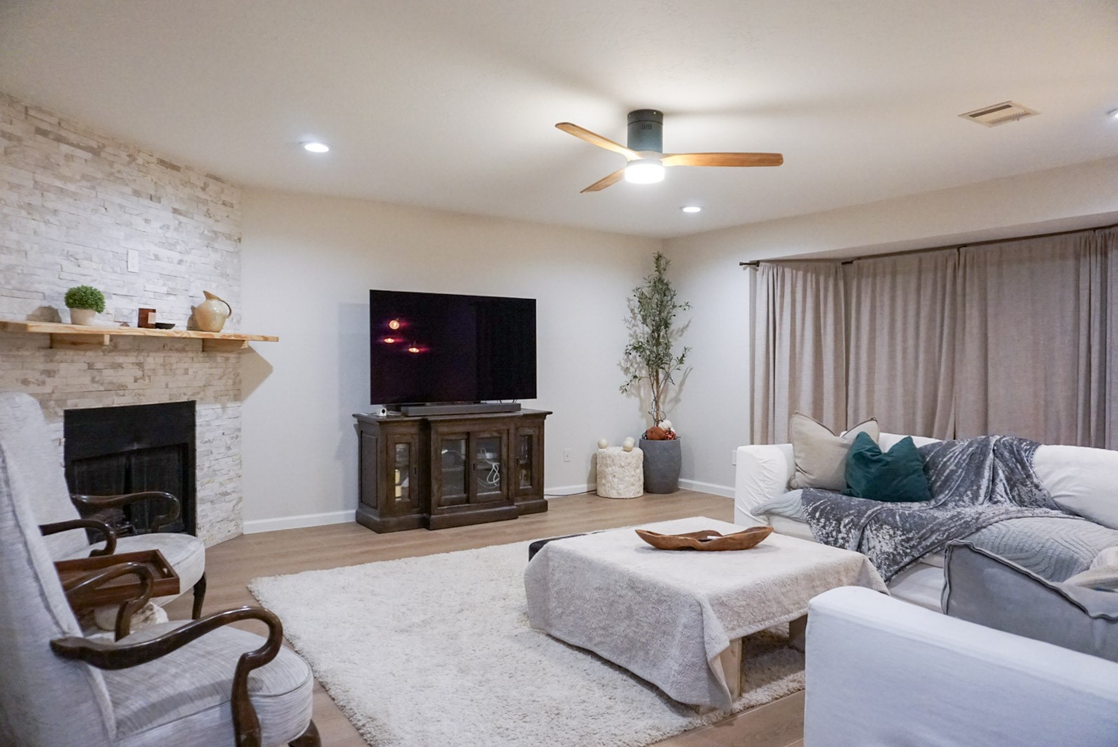 Living room with beautiful stone gas fireplace, ceiling fan, LED lights (with dimmed setting accessible)