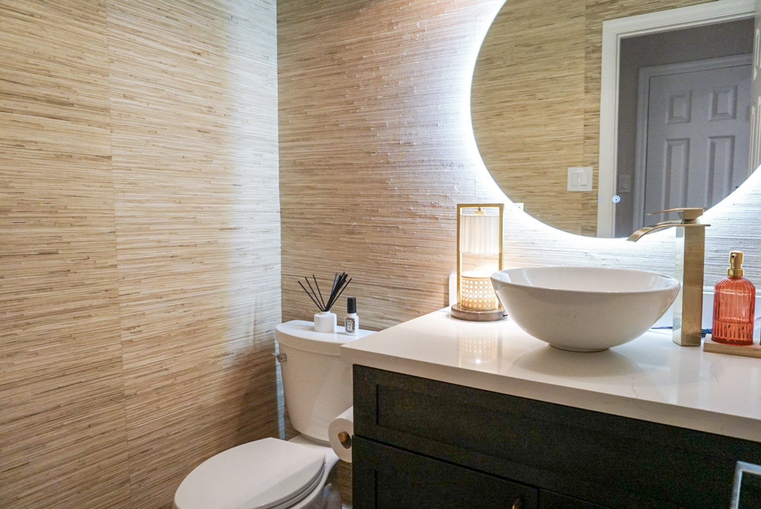 Half bathroom downstairs with grasscloth wallpaper, LED mirror, design-forward updates