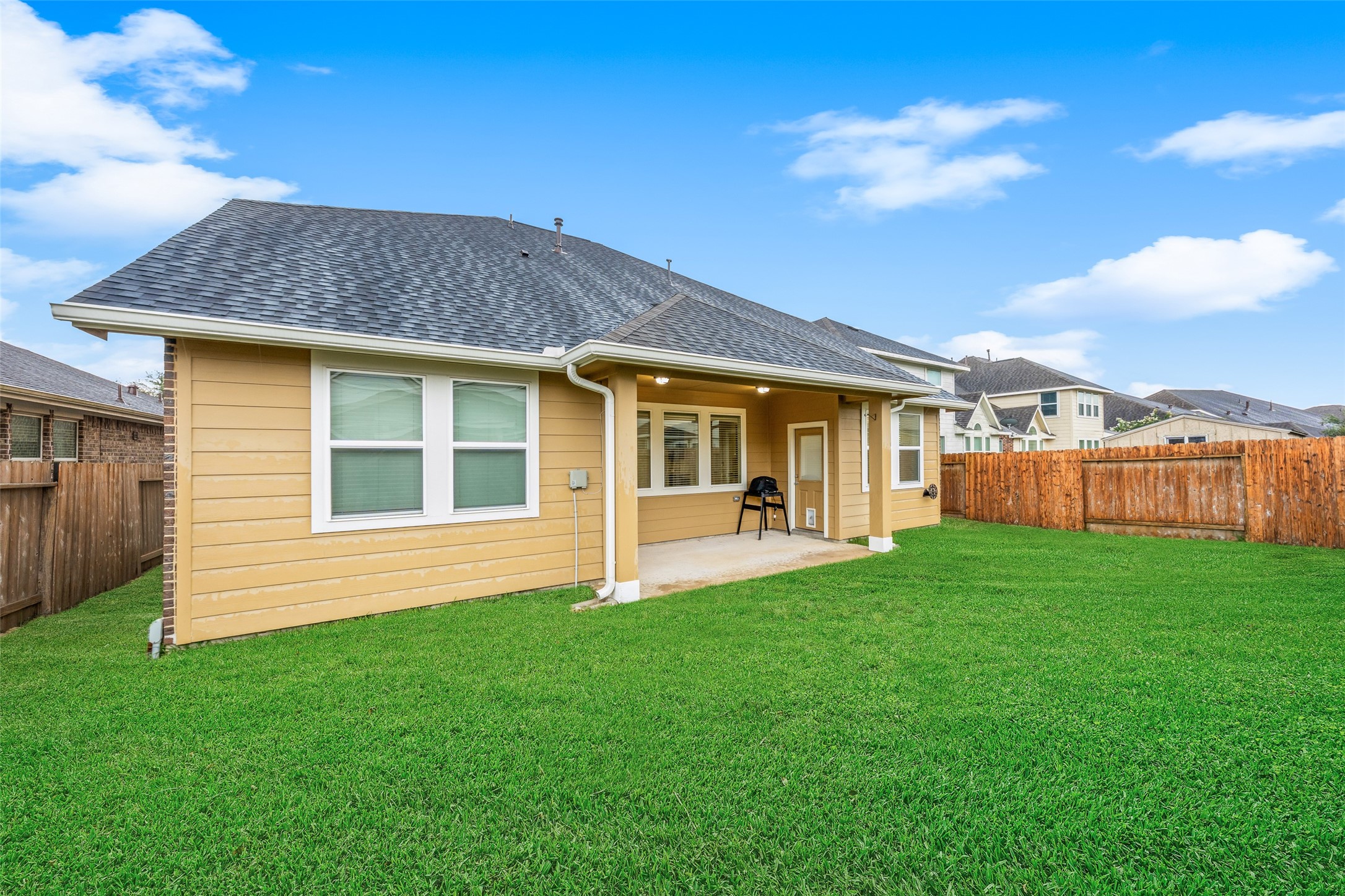 Another view of backpatio and yard showcases how spacious the yard is.