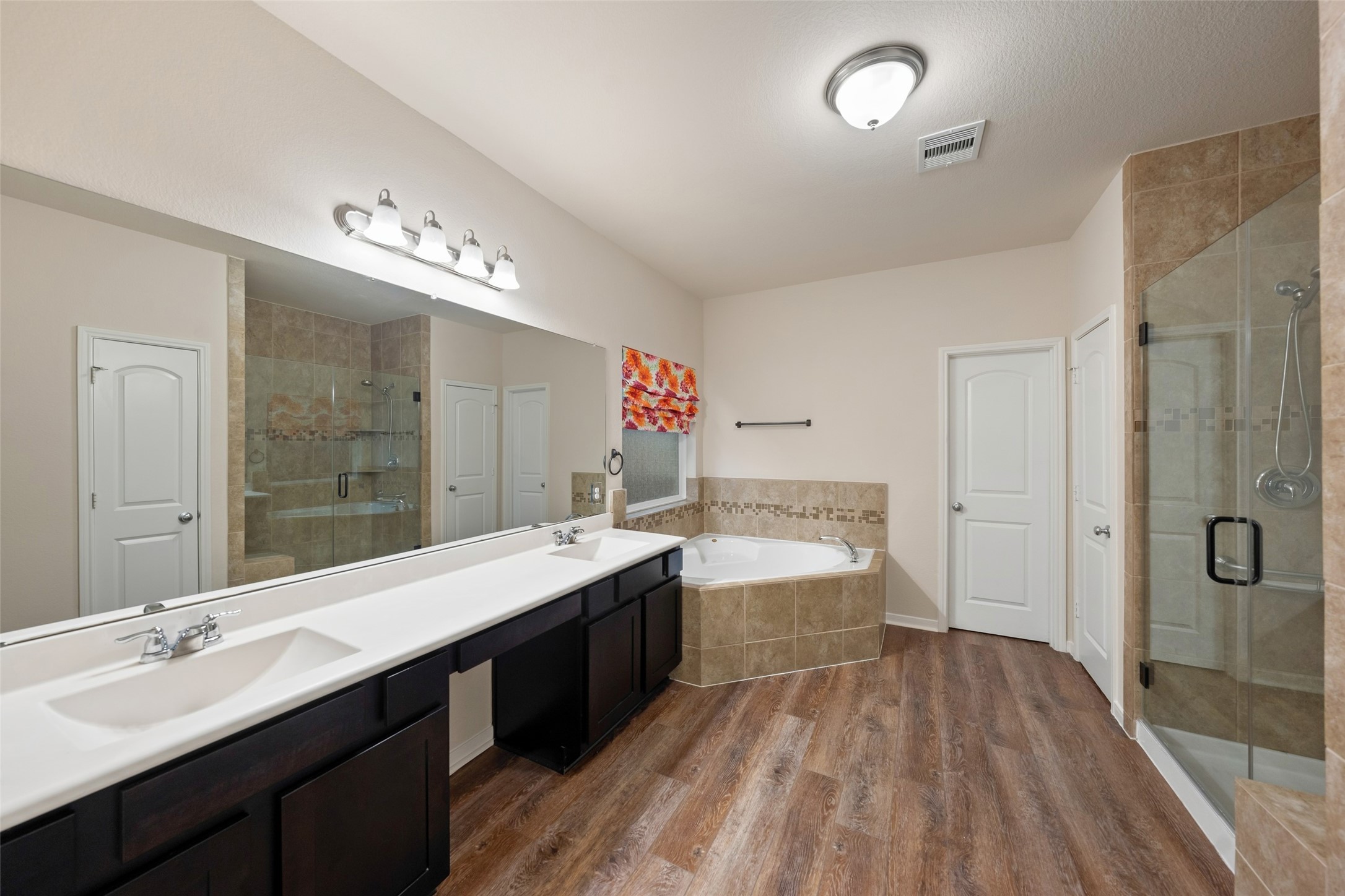 Spacious, double vanity primary bathroom with soaking garden tub and separate shower bathroom with sepa