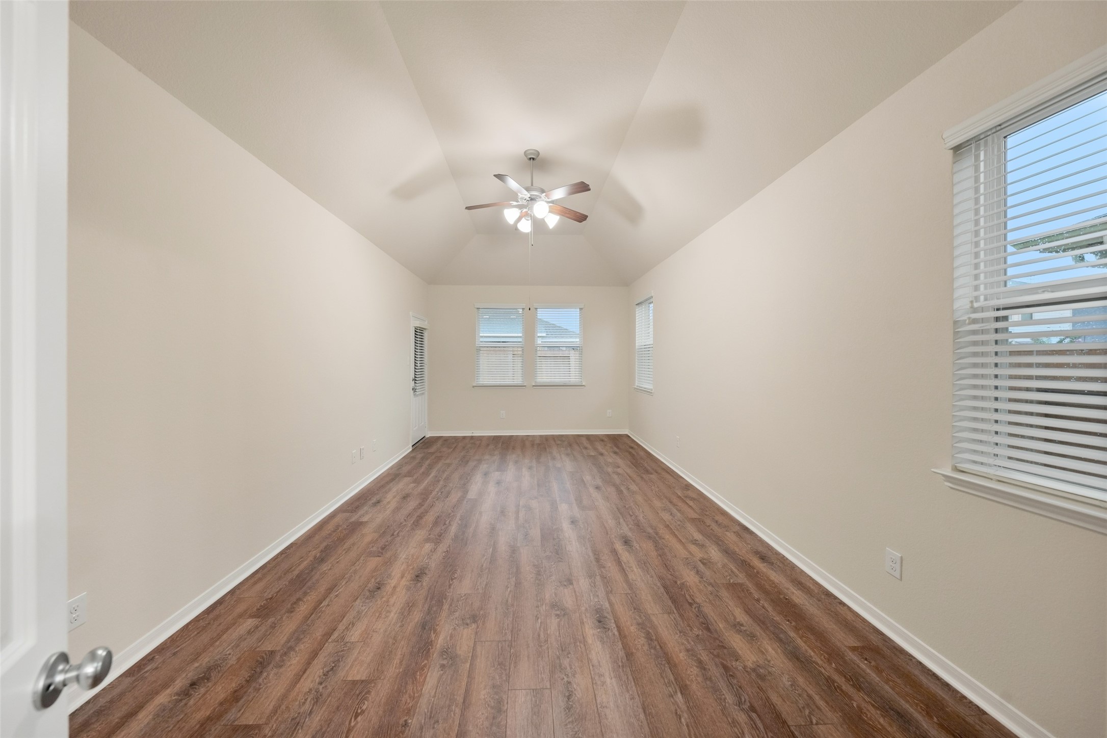 Another view of the primary bedroom highlighting your own private access to the back patio! Also notice all the windows  that are able to let in plenty of morning light.
