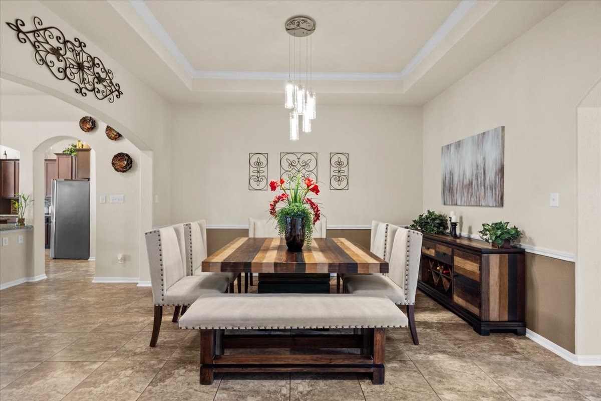 Formal dining room with elegant chandelier and plenty of room for hosting.