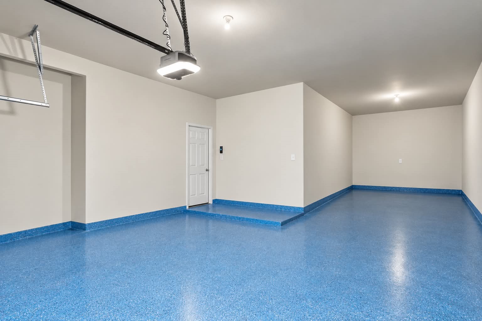 Garage with a coated floor, ready for vehicles, hobbies, or storage. Garage with a coated floor, ready for vehicles, hobbies, or storage.