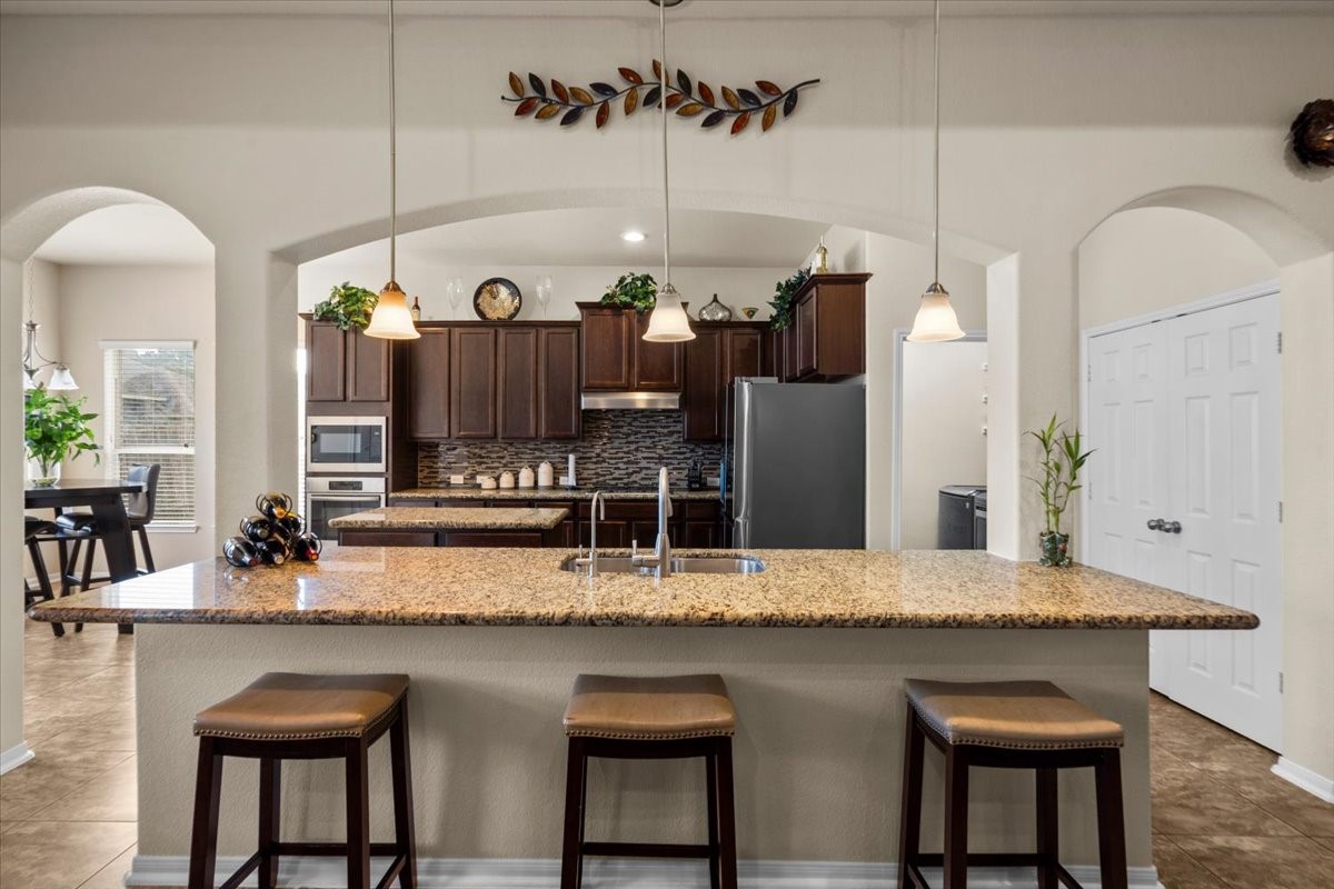 Oversized granite breakfast bar with seating for casual meals.