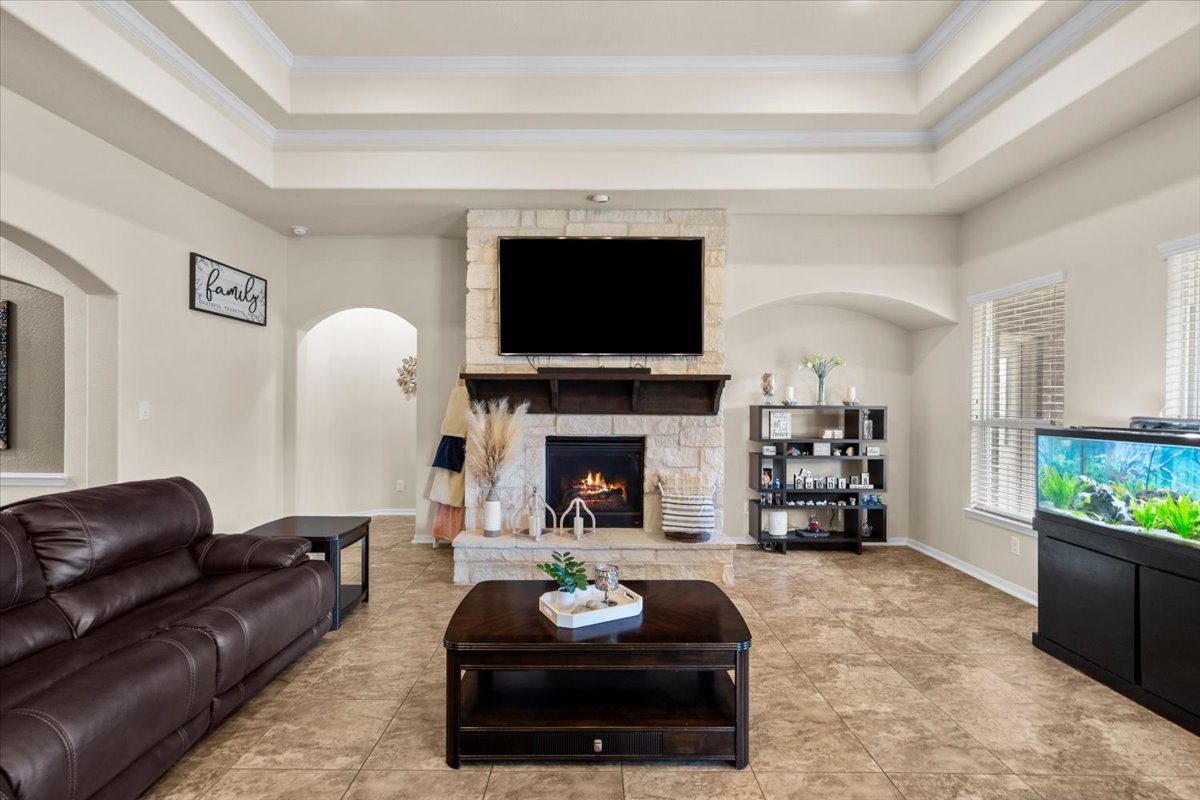 Family room centered around the fireplace with beautiful tray ceiling detail.