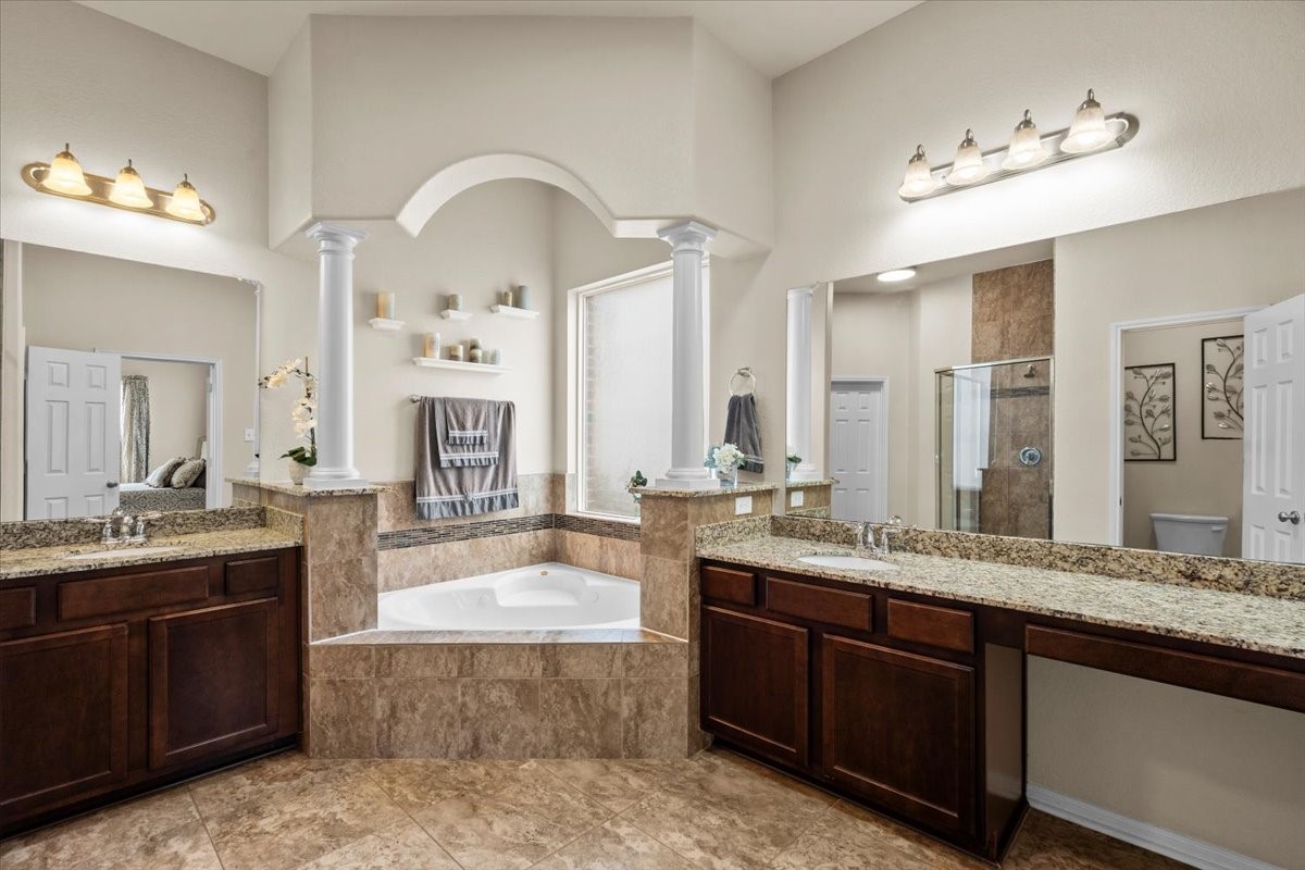 Primary bath with dual vanities and a corner soaking tub.