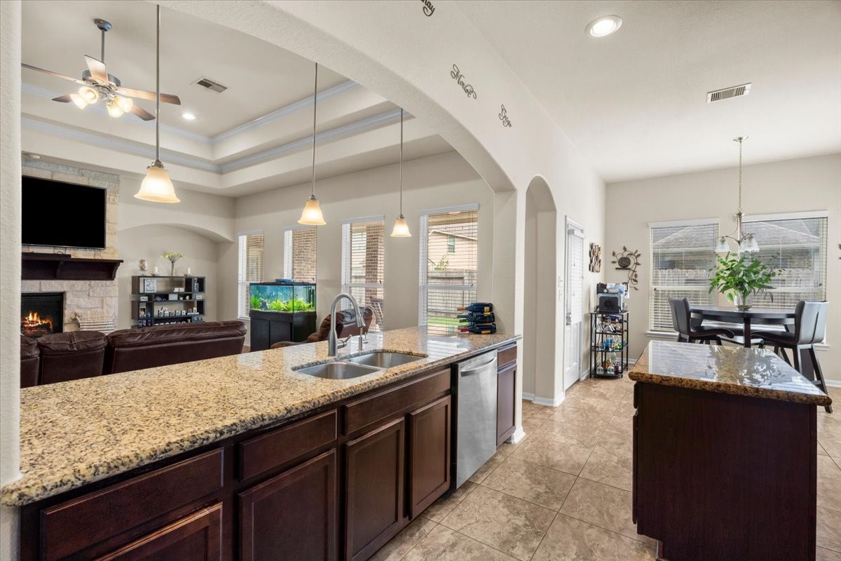 Granite counters and a long breakfast bar connect the kitchen to the living space.