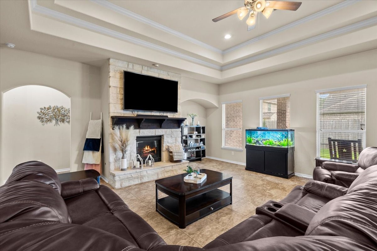 Spacious family room with tray ceiling, cozy fireplace, and room for everyone to gather.