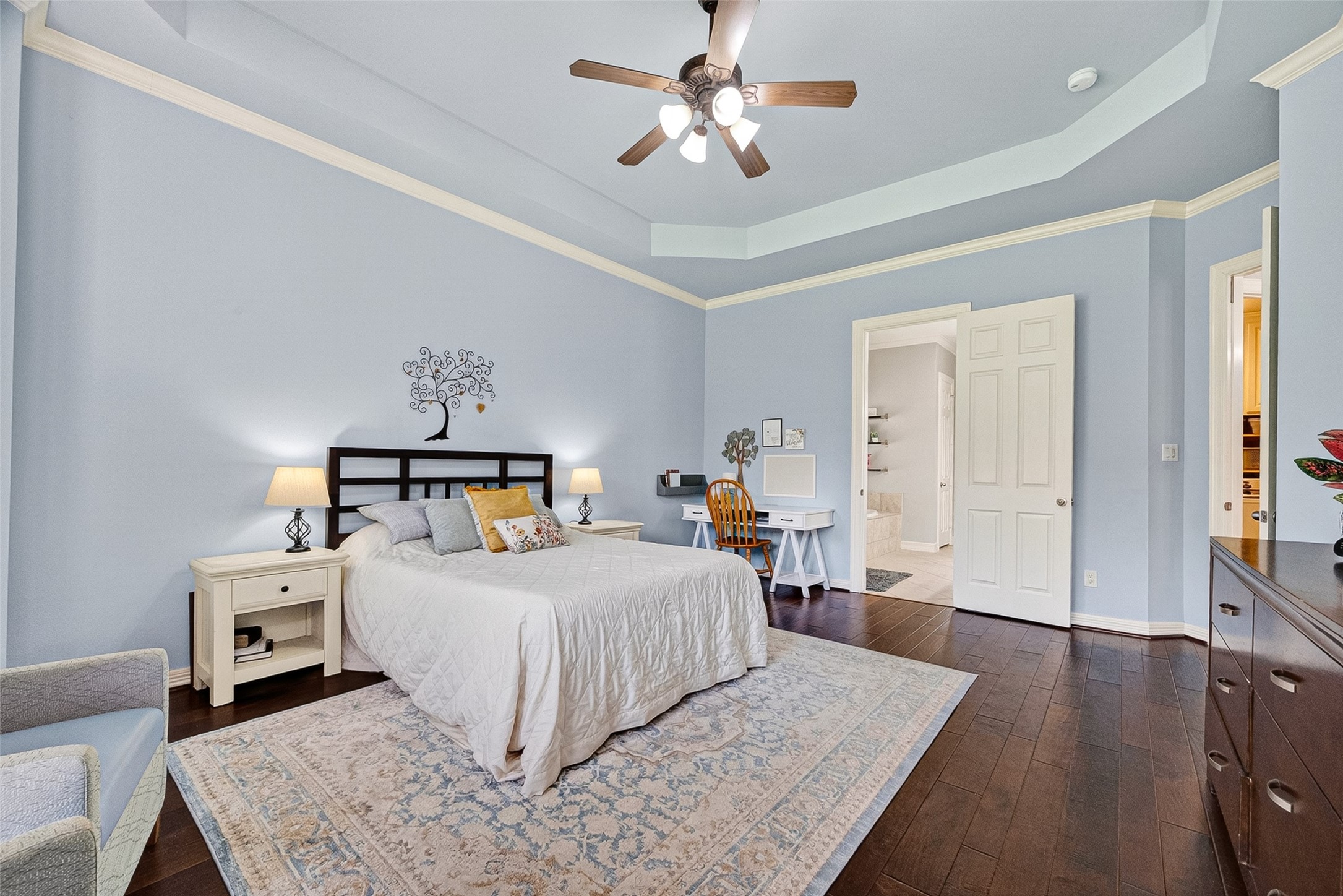 Downstairs primary suite with bay windows and tray ceiling.