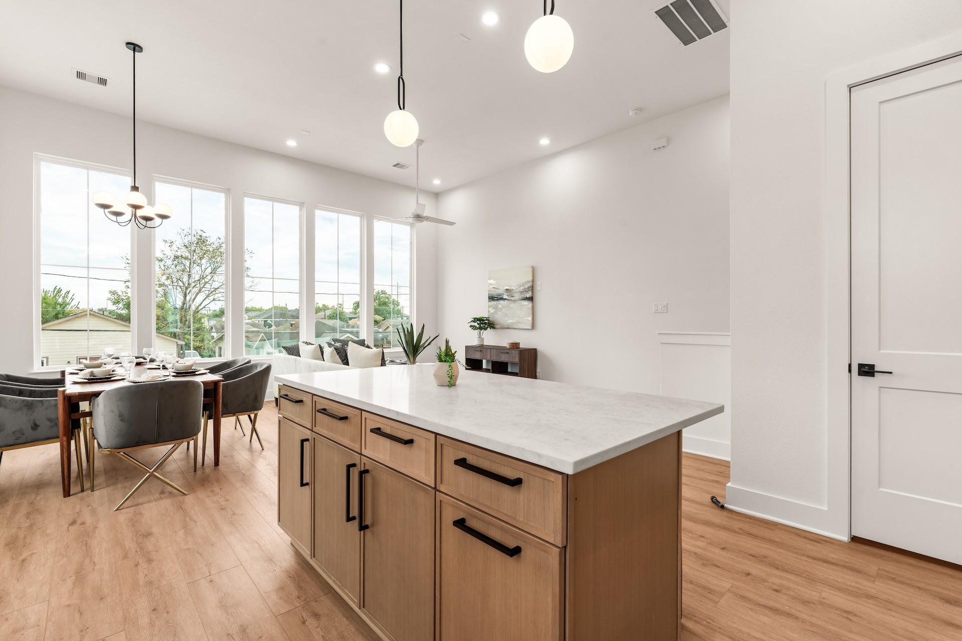 Large kitchen island with breakfast bar seating overlooking the light-filled dining and living spaces.