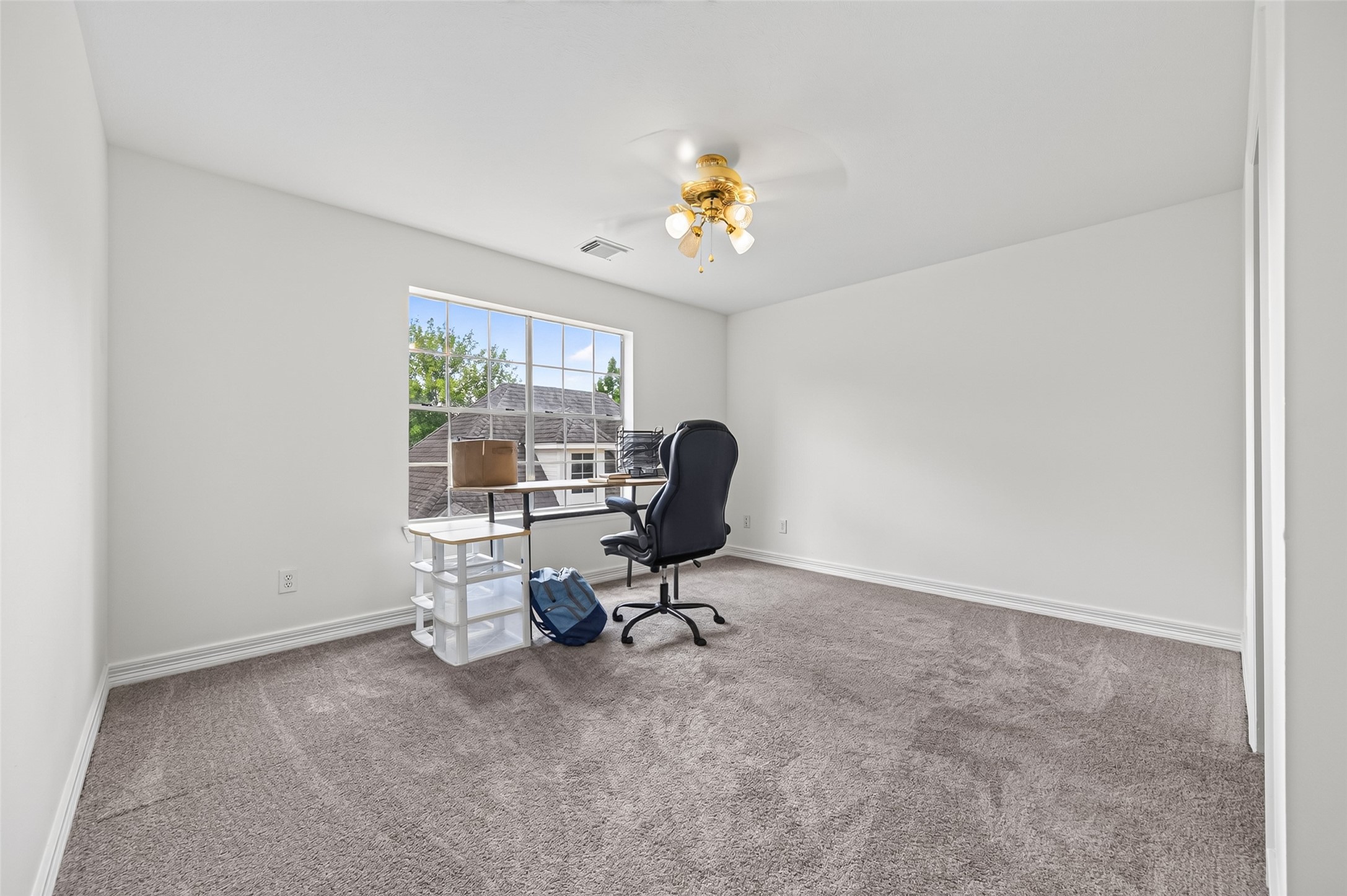 Bright and spacious room with carpeting, featuring a large window that invites natural light.