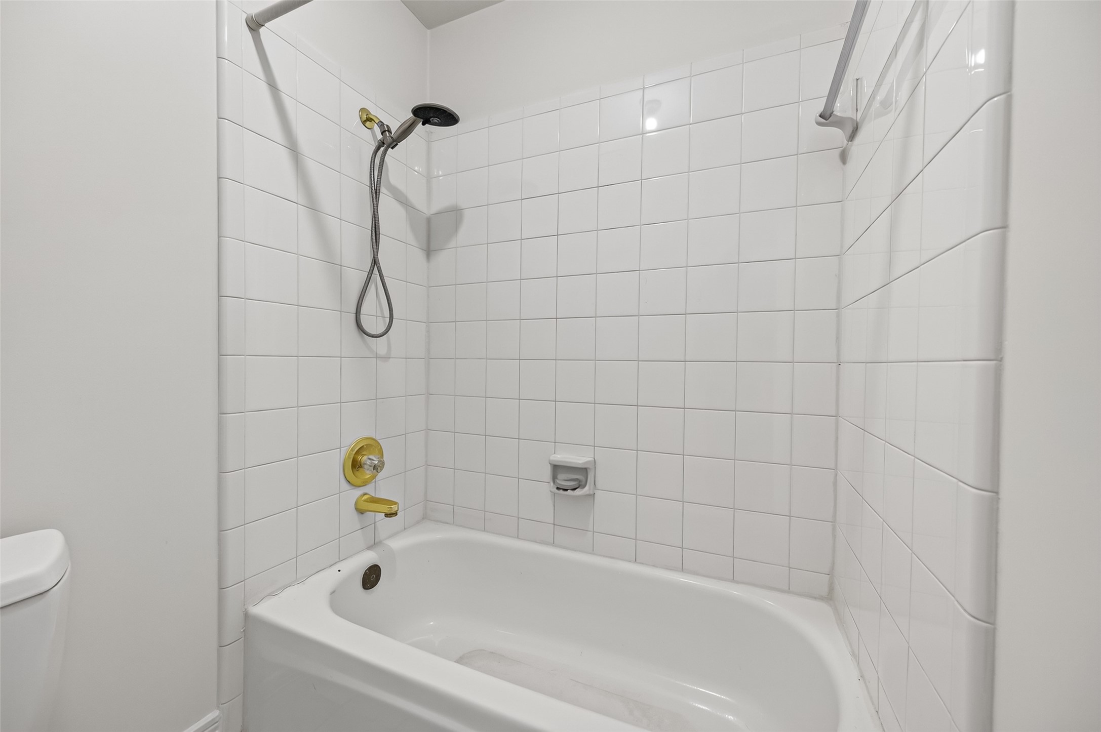 Bright and clean bathroom featuring a classic white tile shower and tub, perfect for relaxation.
