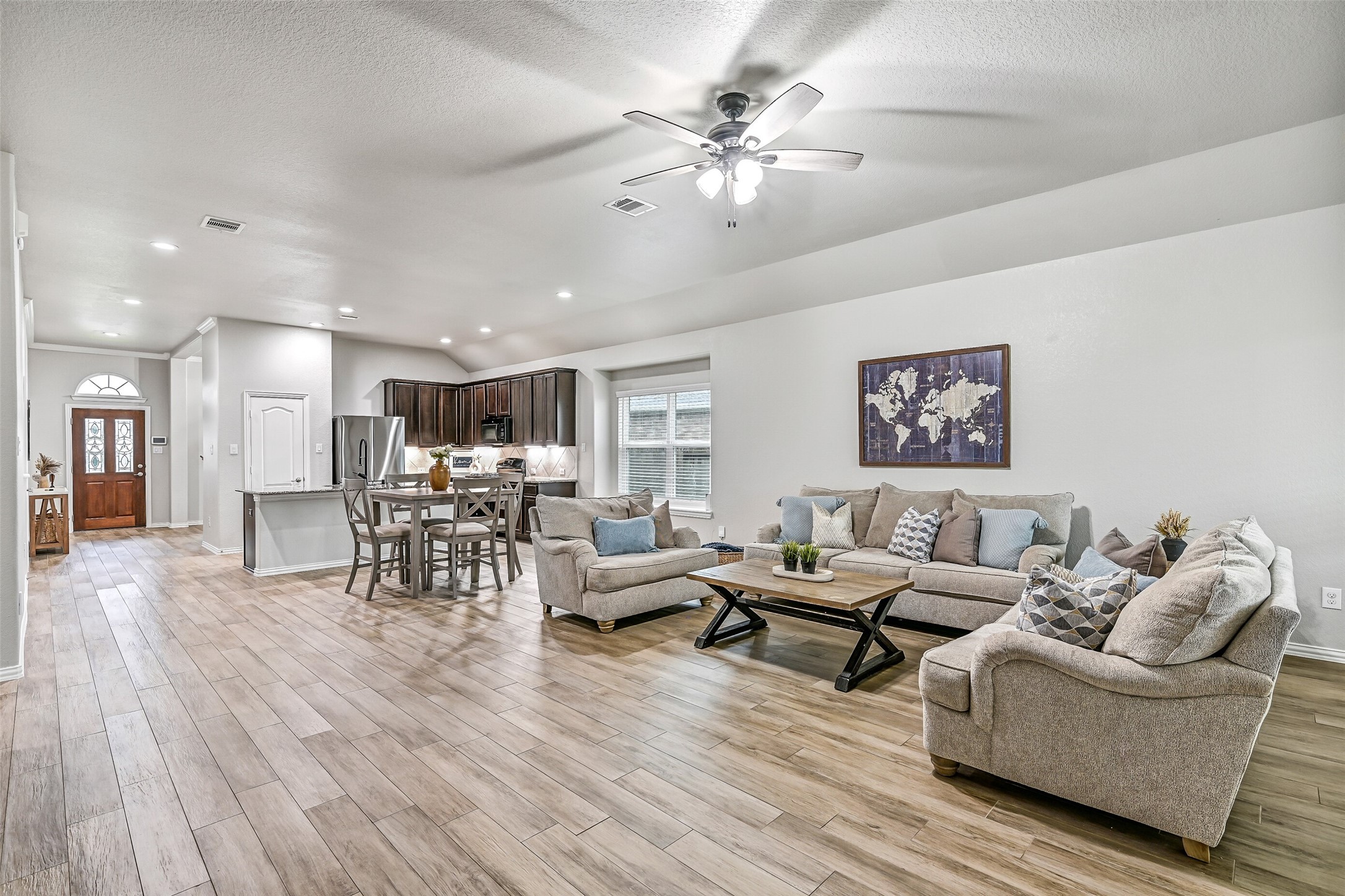 Another view of the family room showcases its generous proportions and versatile layout. Large rear windows invite natural light inside while offering views of the oversized backyard and covered patio beyond.