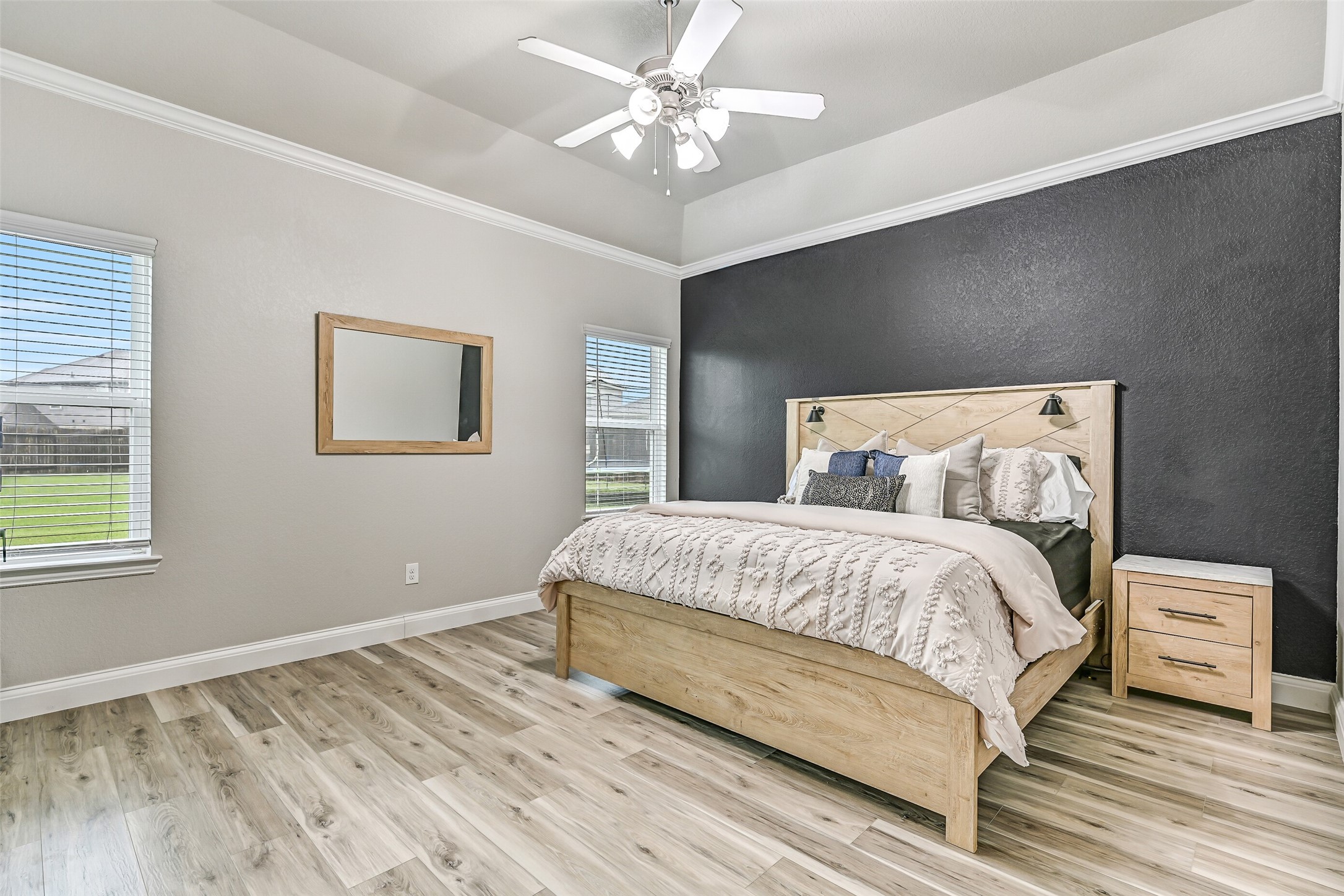 Tucked away at the back of the home, the private primary suite offers a peaceful retreat with elevated ceilings, abundant natural light, new wood-look tile flooring, and plenty of space for oversized furnishings while maintaining a calm, relaxing atmosphere.