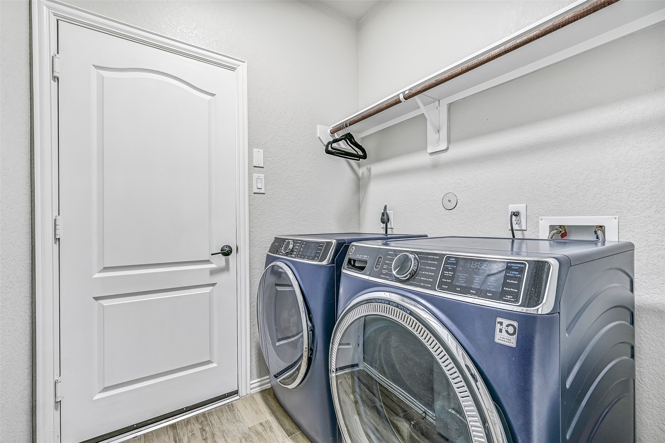 Conveniently located near the secondary bedrooms, the utility room offers upper hanging space and room for full-size washer and dryer, making laundry day both practical and efficient.